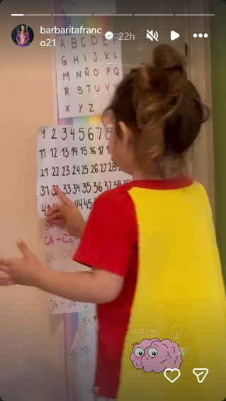 Sarah Burlando en su habitación jugando con un educativo cartel con números que le instaló su mamá | Fuente: Instagram Stories/barbaritafranco21