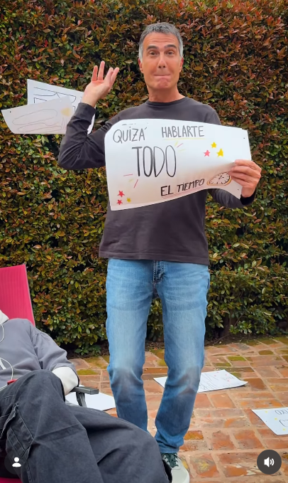 Con un simpático gesto hacia la cámara y arrojando una hoja hacia atrás, Antonio Laje mostró el cartel con el texto "QUIZÁ HABLARTE TODO EL TIEMPO", acompañado por un dibujo de un reloj. A su lado, su hijo Ezequiel continuaba relajado en la reposera durante la grabación del tema "Placer Culposo", compartida el 7 de octubre de 2026. | Fuente: Instagram/leish.ar
