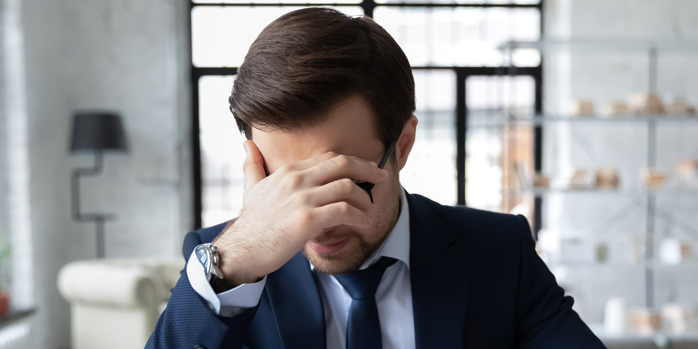 Un hombre apoyando la cabeza en una mano | Fuente: Shutterstock