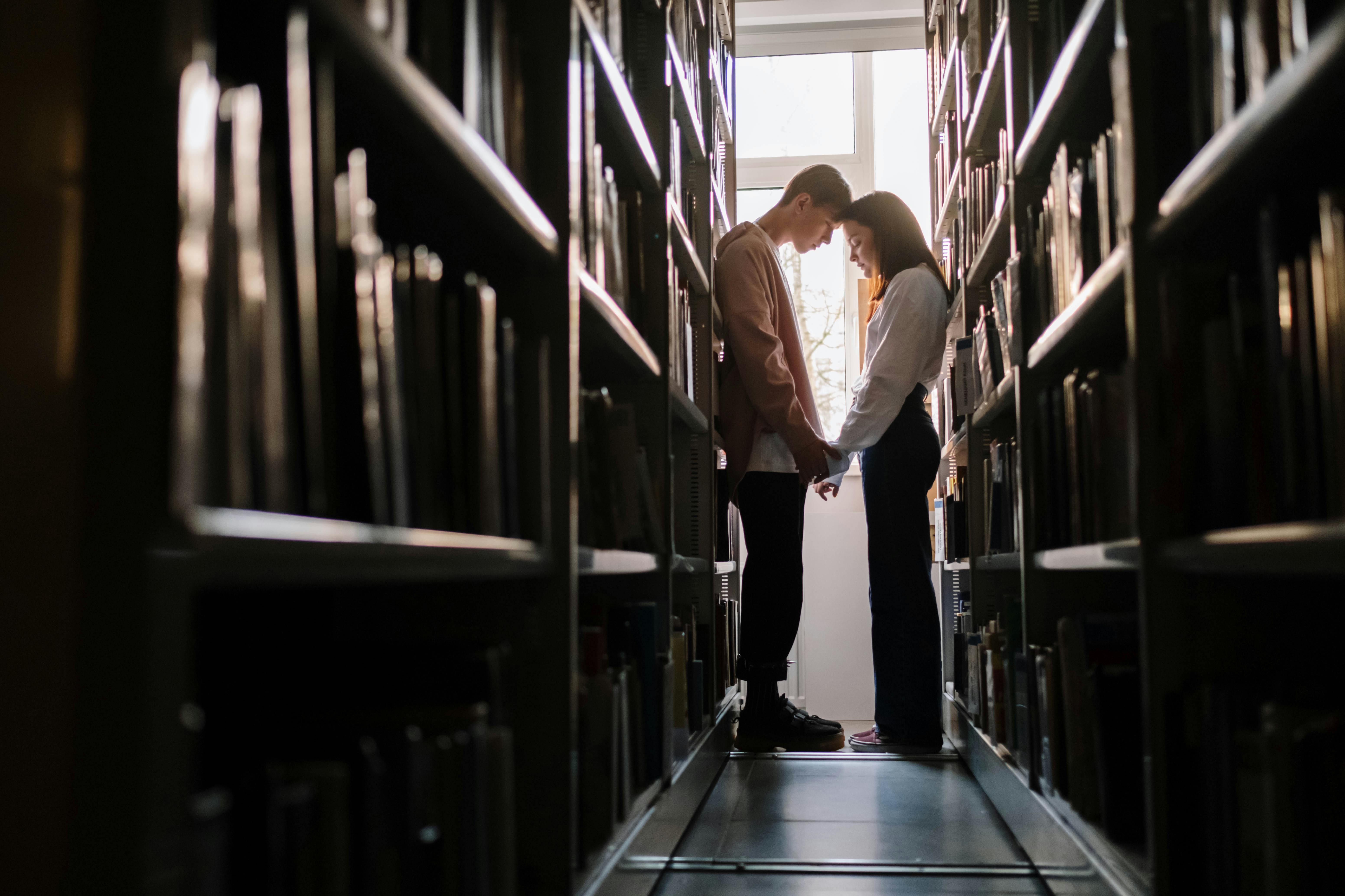 Una pareja reunida en una biblioteca | Foto: Pexels