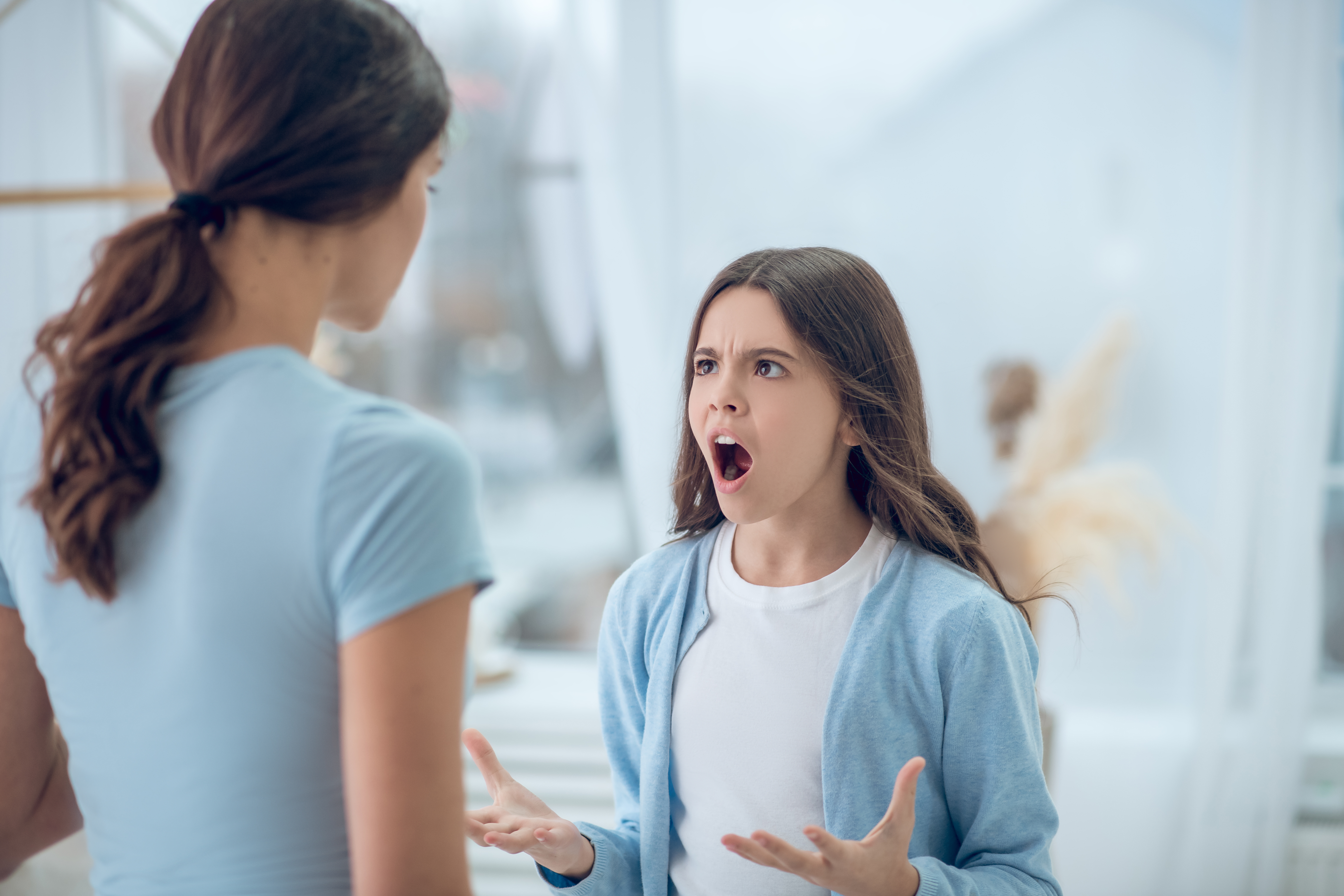 Una adolescente gritando a la mujer que está frente a ella. | Foto: Shutterstock