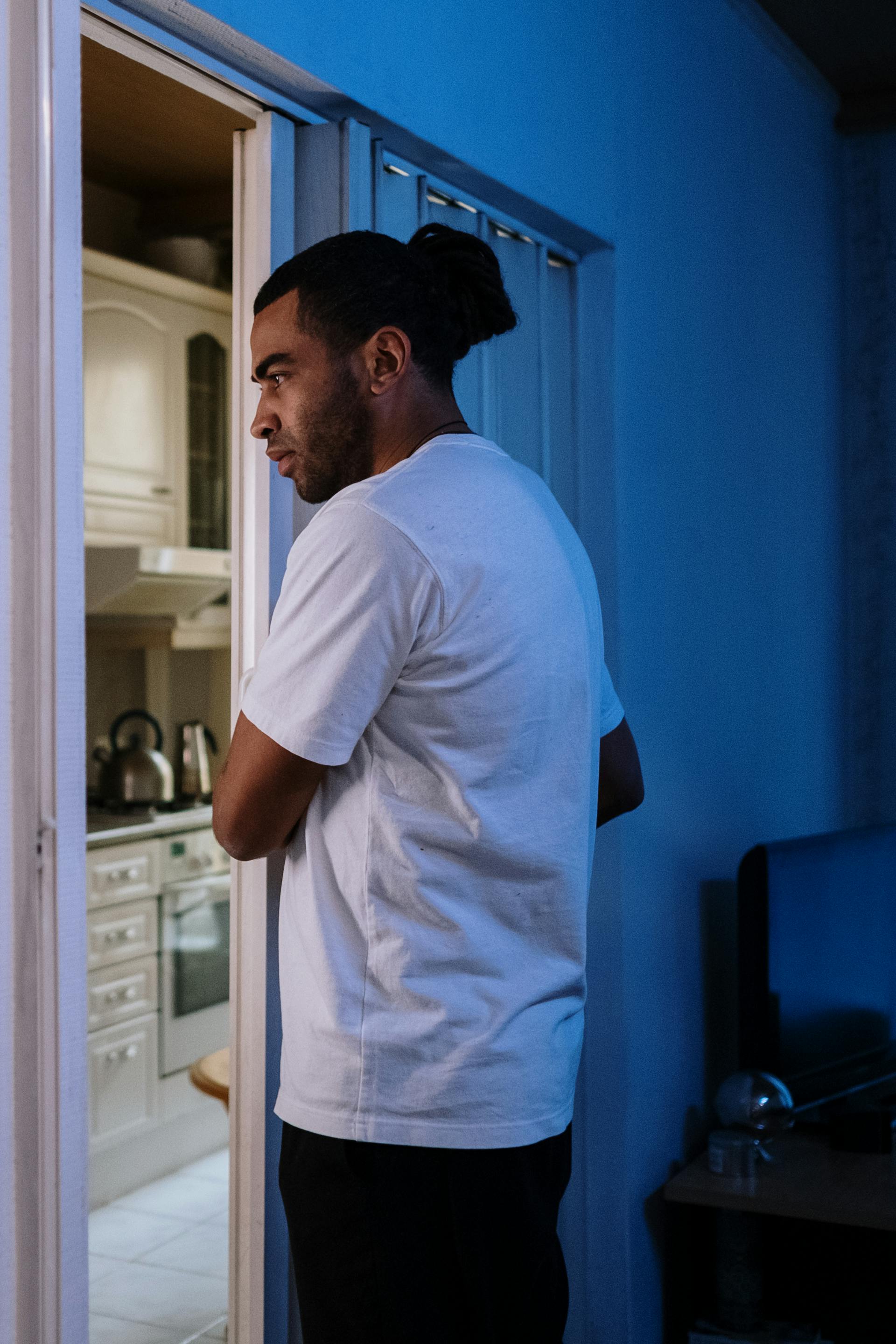 Un hombre triste entrando en una cocina | Fuente: Pexels