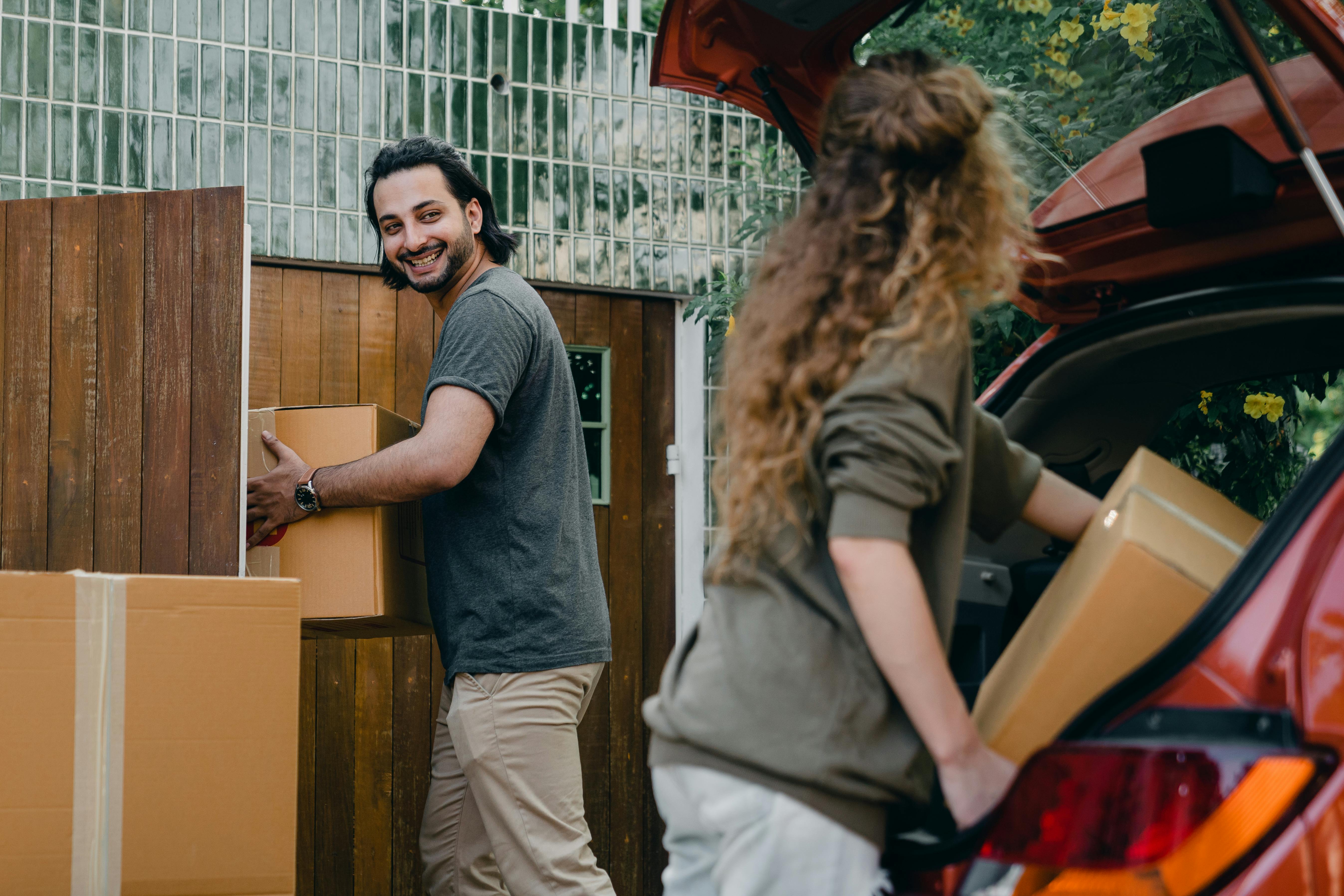 Una pareja descarga cajas de un Automóvil | Fuente: Pexels