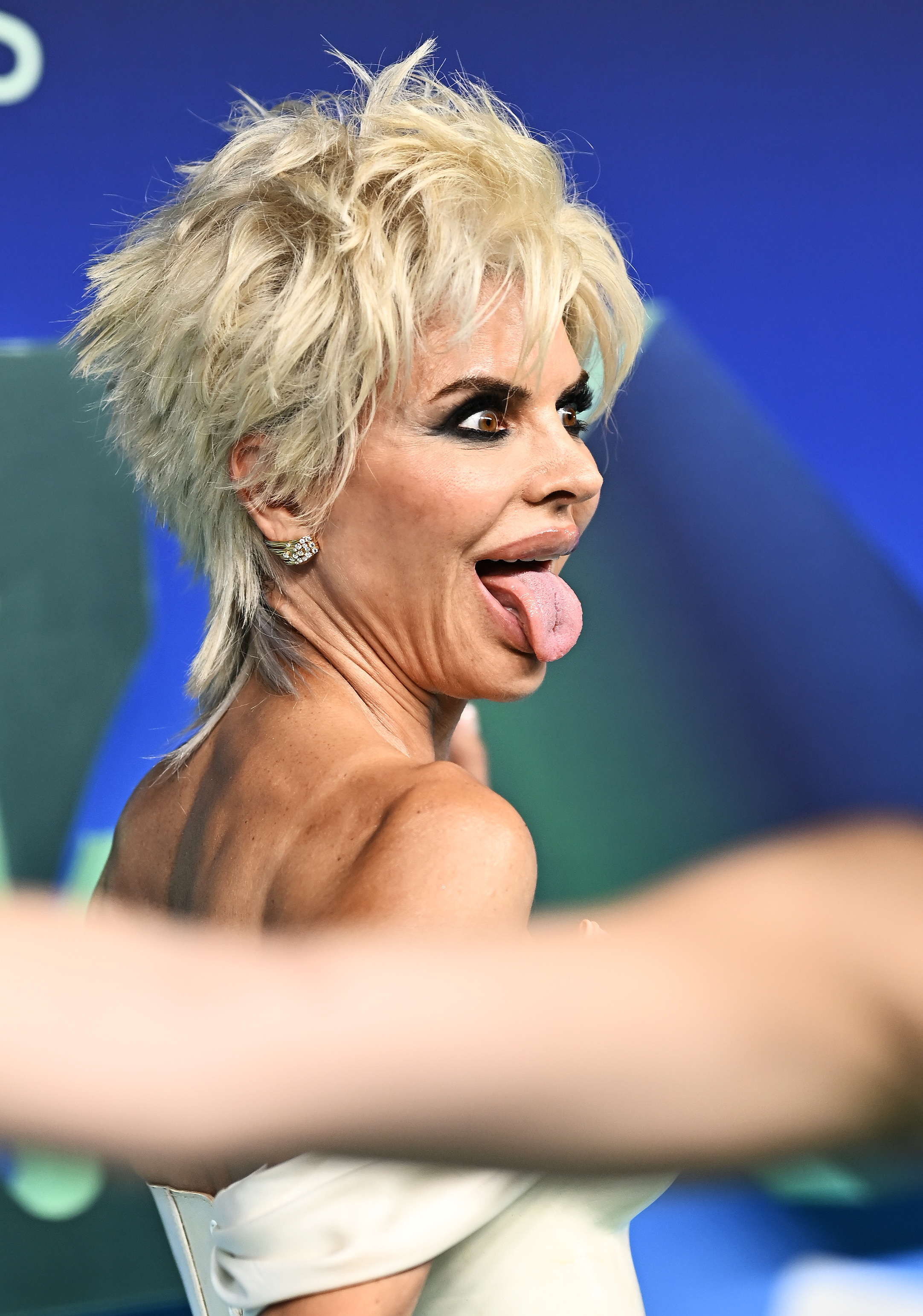 Rinna dejó ver su lado más juguetón al girarse hacia las cámaras y sacar la lengua. El primer plano también permitió apreciar mejor su corte escalado platino y su llamativo maquillaje de ojos. | Fuente: Getty Images
