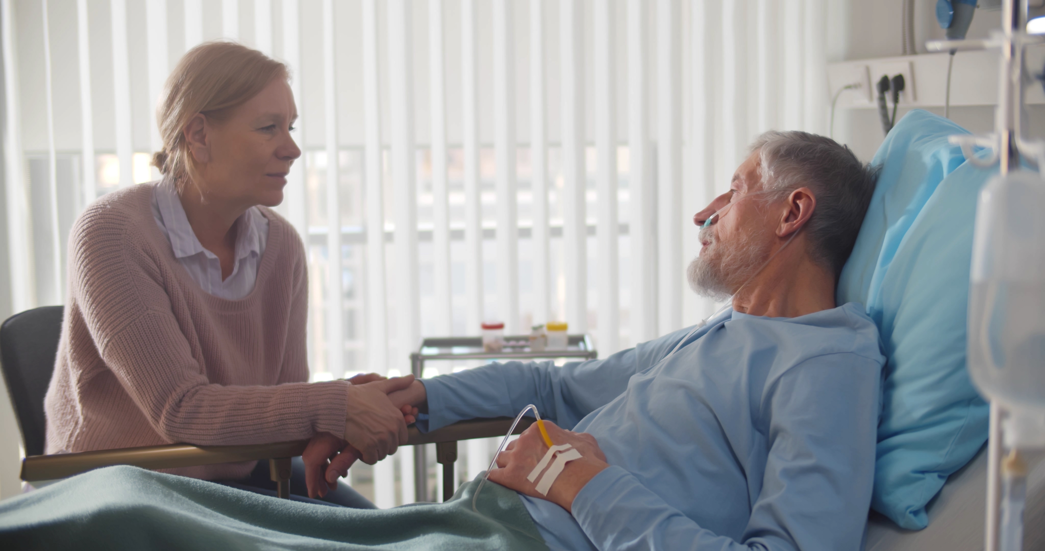 Una esposa coge la mano de su marido enfermo en el hospital | Fuente: Shutterstock