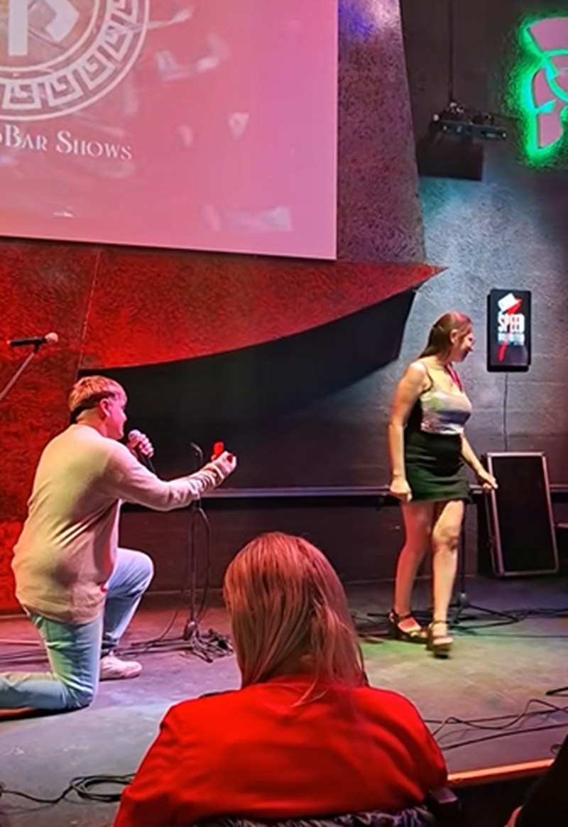 Hombre de rodillas mostrando un anillo a su pareja durante el recital de Daniel Agostini en Buenos Aires mientras ella se gira para abandonar el escenario | Fuente: TikTok/marielita533
