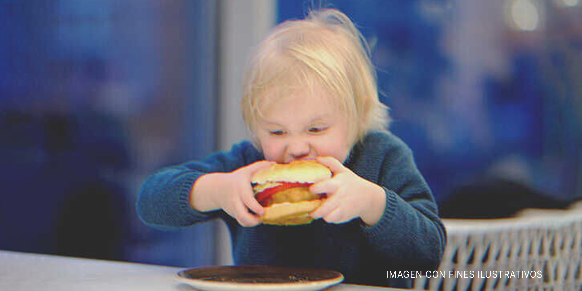 Un niño comiendo una hamburguesa. | Foto: Shutterstock