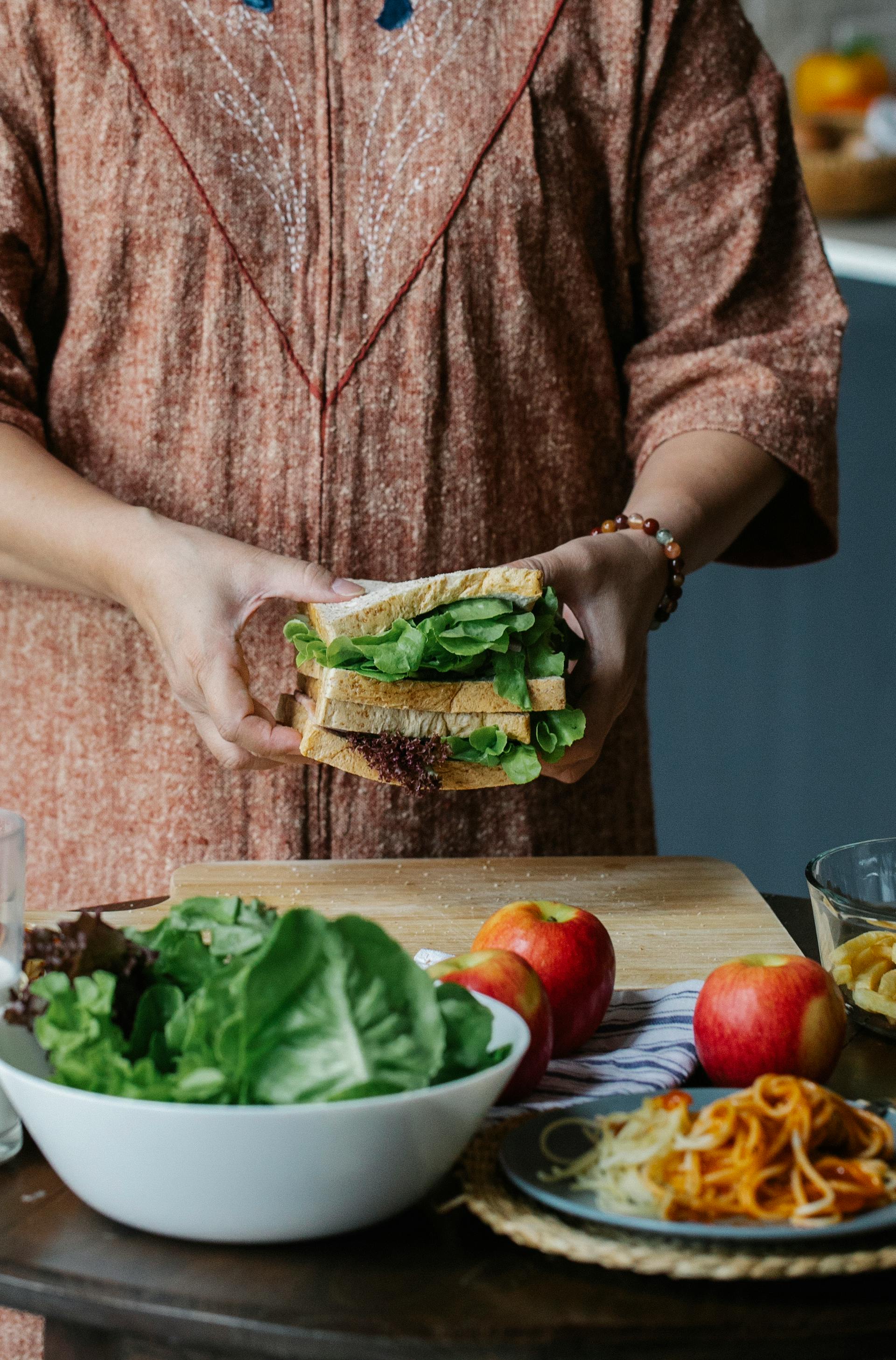 Primer plano de una mujer preparando un bocadillo en la cocina | Fuente: Pexels