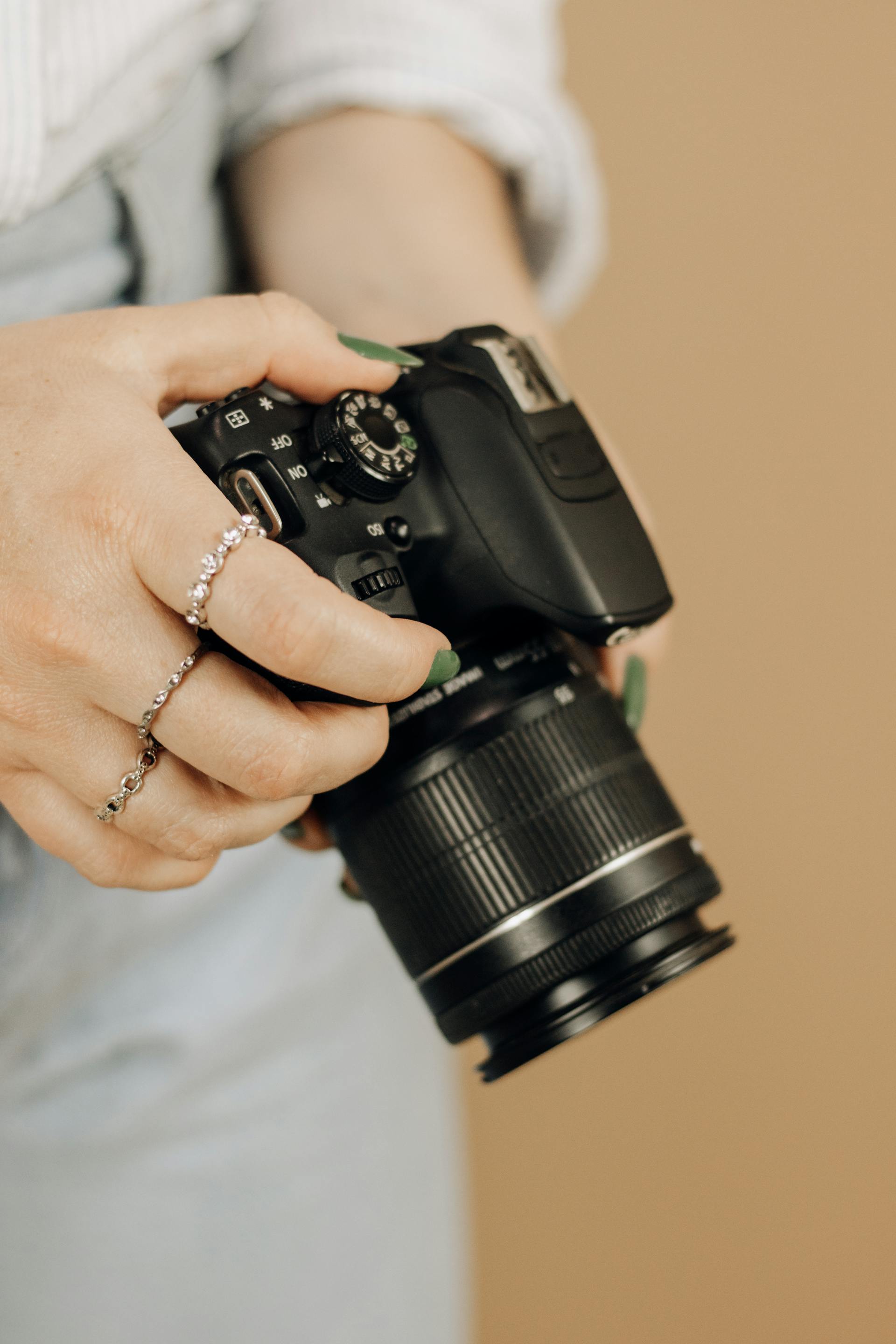 Una mujer sujetando una cámara | Fuente: Pexels