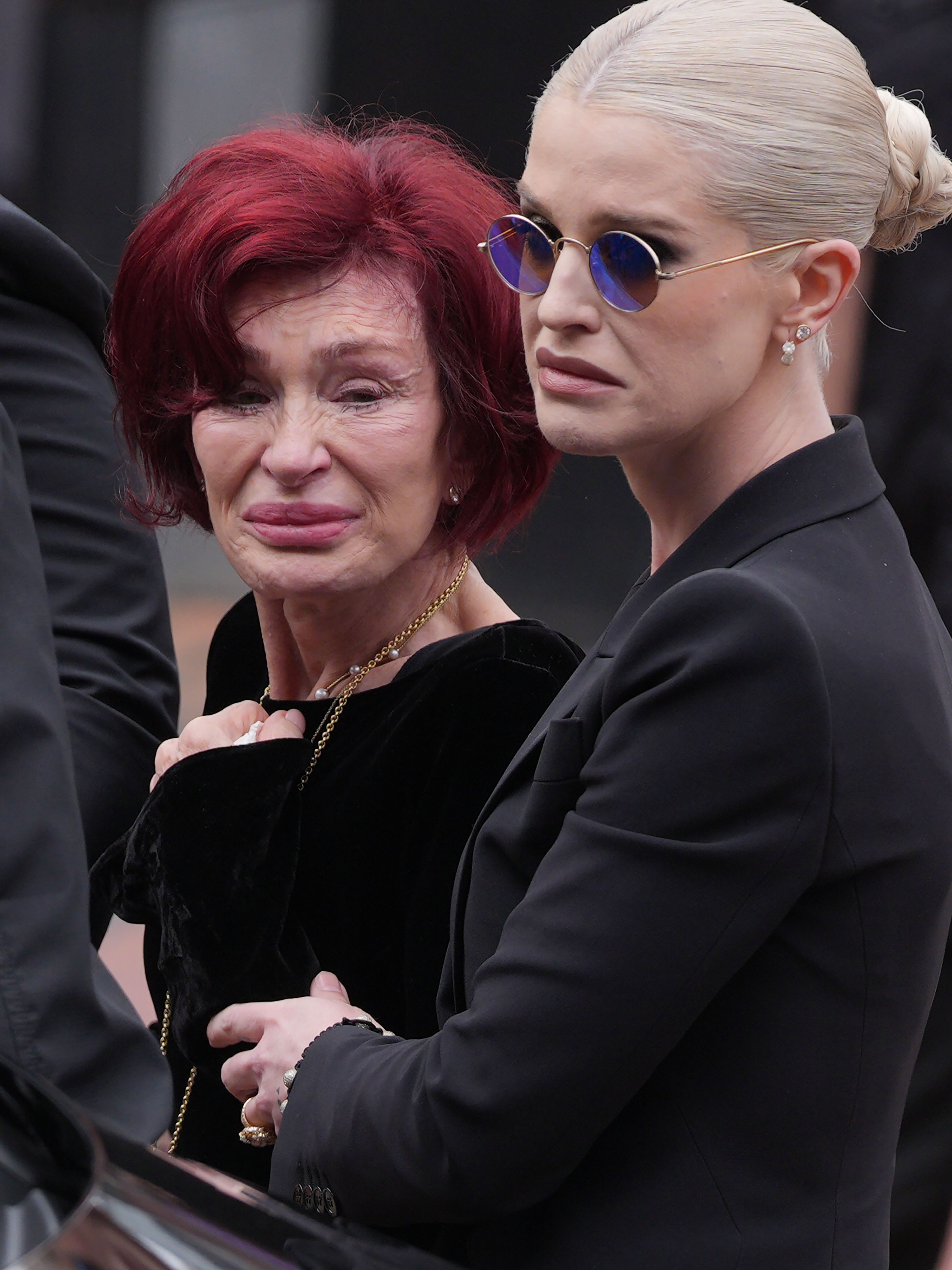 Kelly Osbourne abrazó con fuerza a su madre, Sharon, que se mostraba visiblemente emocionada, mientras lloraban la pérdida de Ozzy Osbourne en Birmingham el 30 de julio de 2025, solo ocho días después de su fallecimiento. | Fuente: Getty Images.