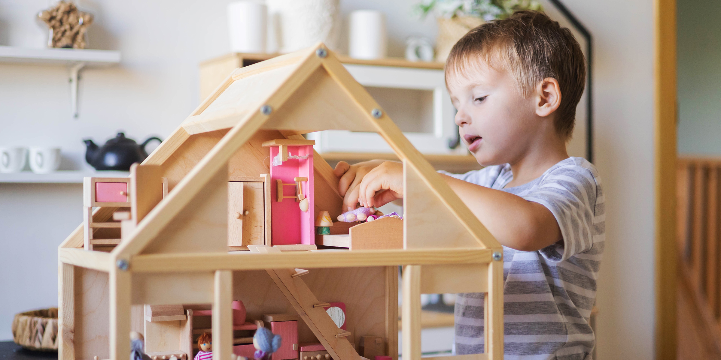 Un niño jugando con una casa de muñecas | Fuente: Shutterstock