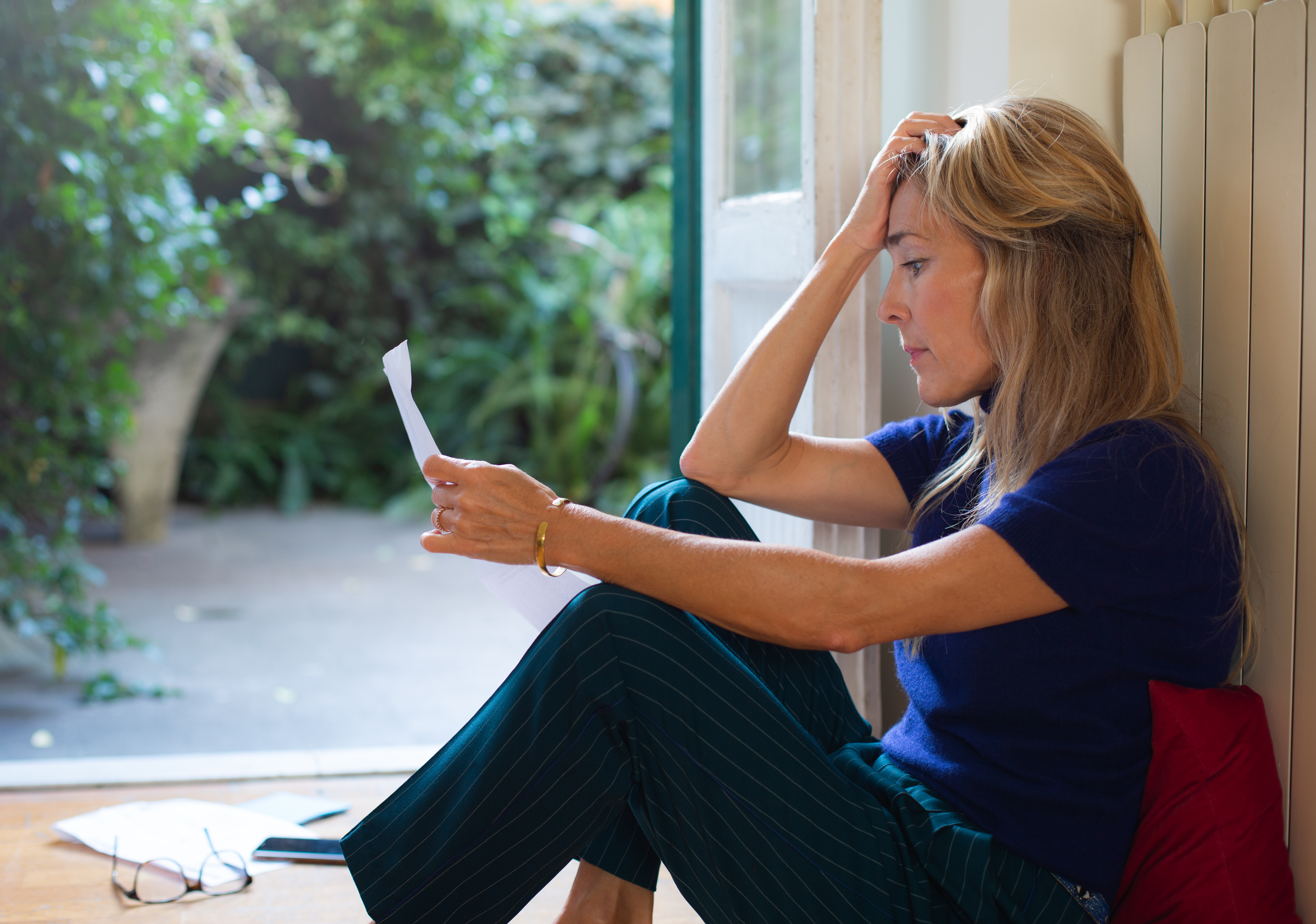 Mujer leyendo una carta, con aspecto abrumado | Fuente: Getty Images