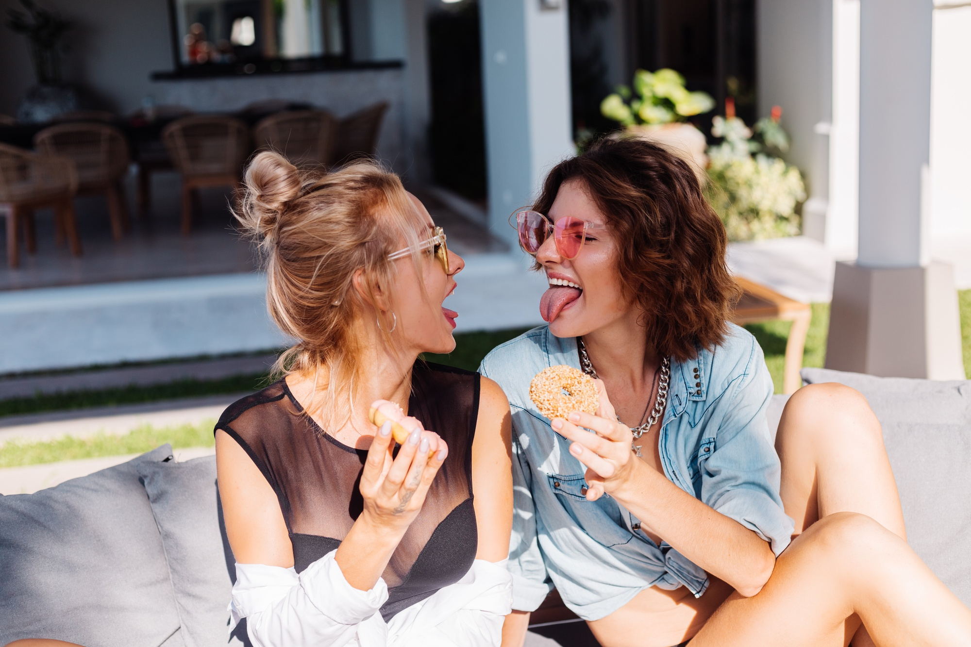 Dos mujeres disfrutando de unos donuts y divirtiéndose | Fuente: Freepik