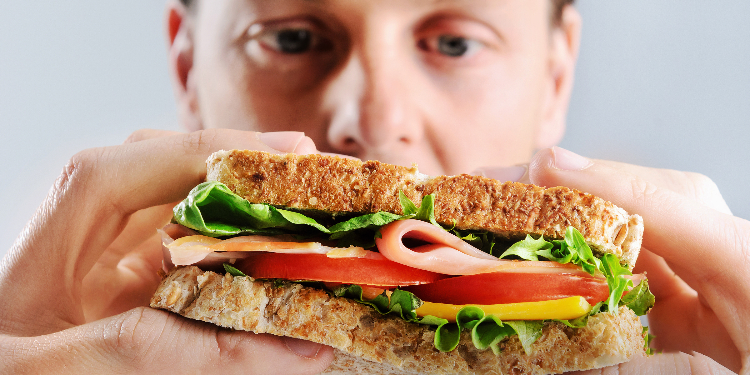 Un hombre mirando un sándwich | Fuente: Shutterstock