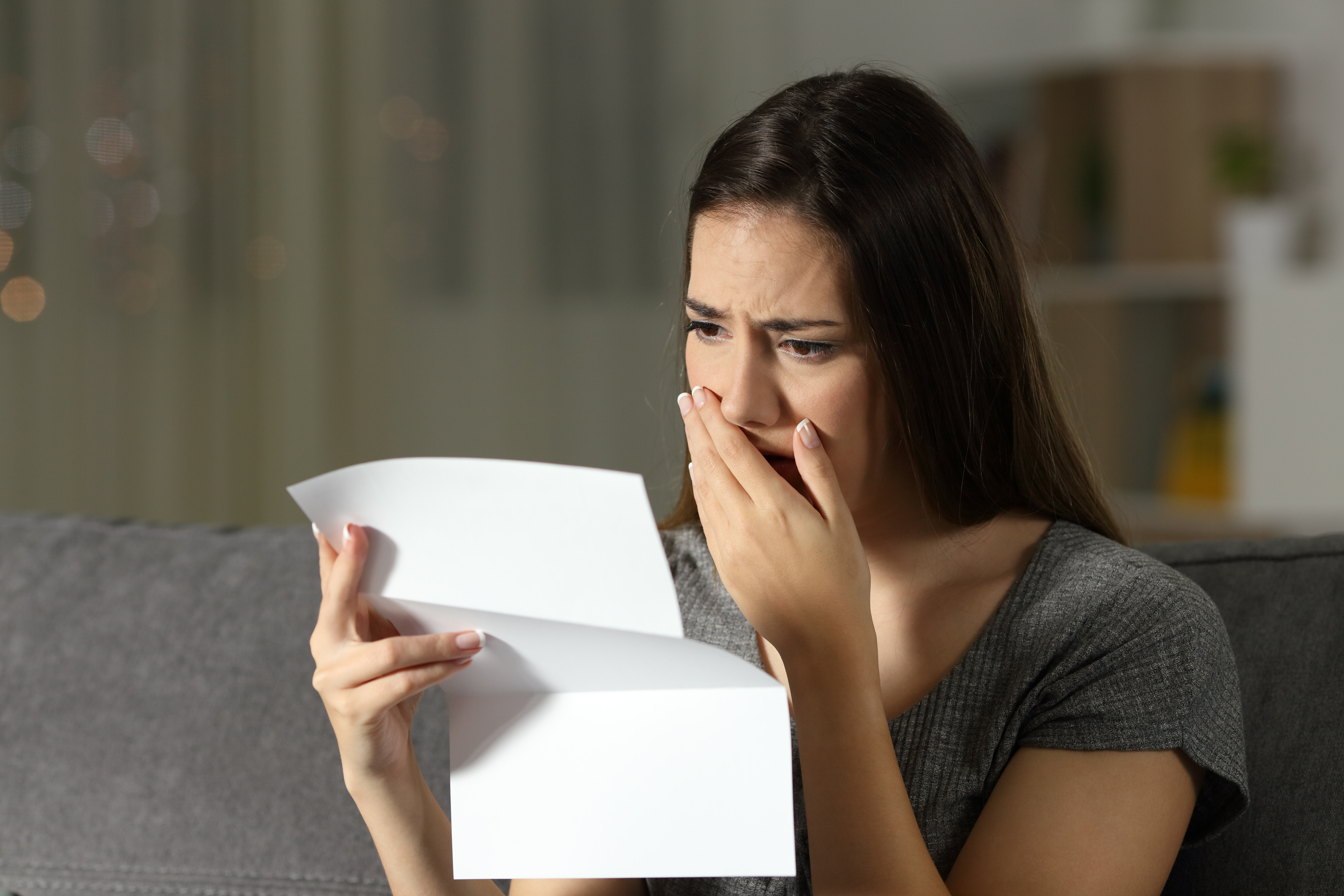 Mujer triste que se queja leyendo una carta. | Fuente: Shutterstock