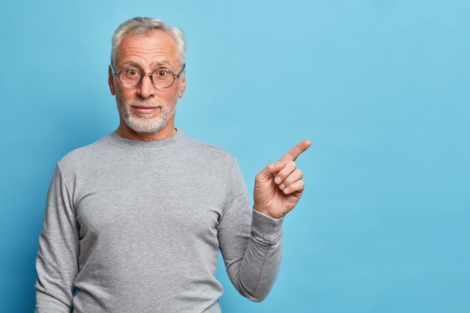 Un anciano sonriente señalando con el dedo | Fuente: Freepik