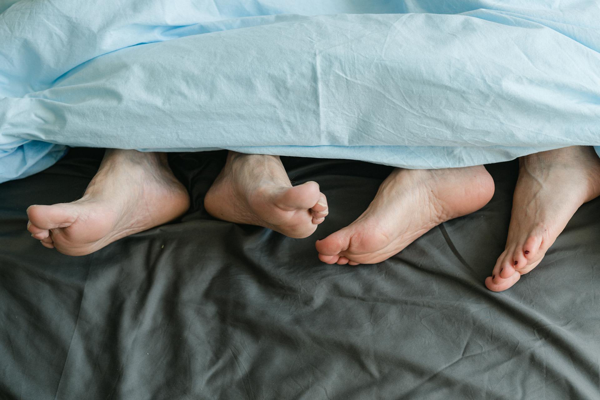 Un hombre tumbado junto a una mujer en la cama | Fuente: Pexels