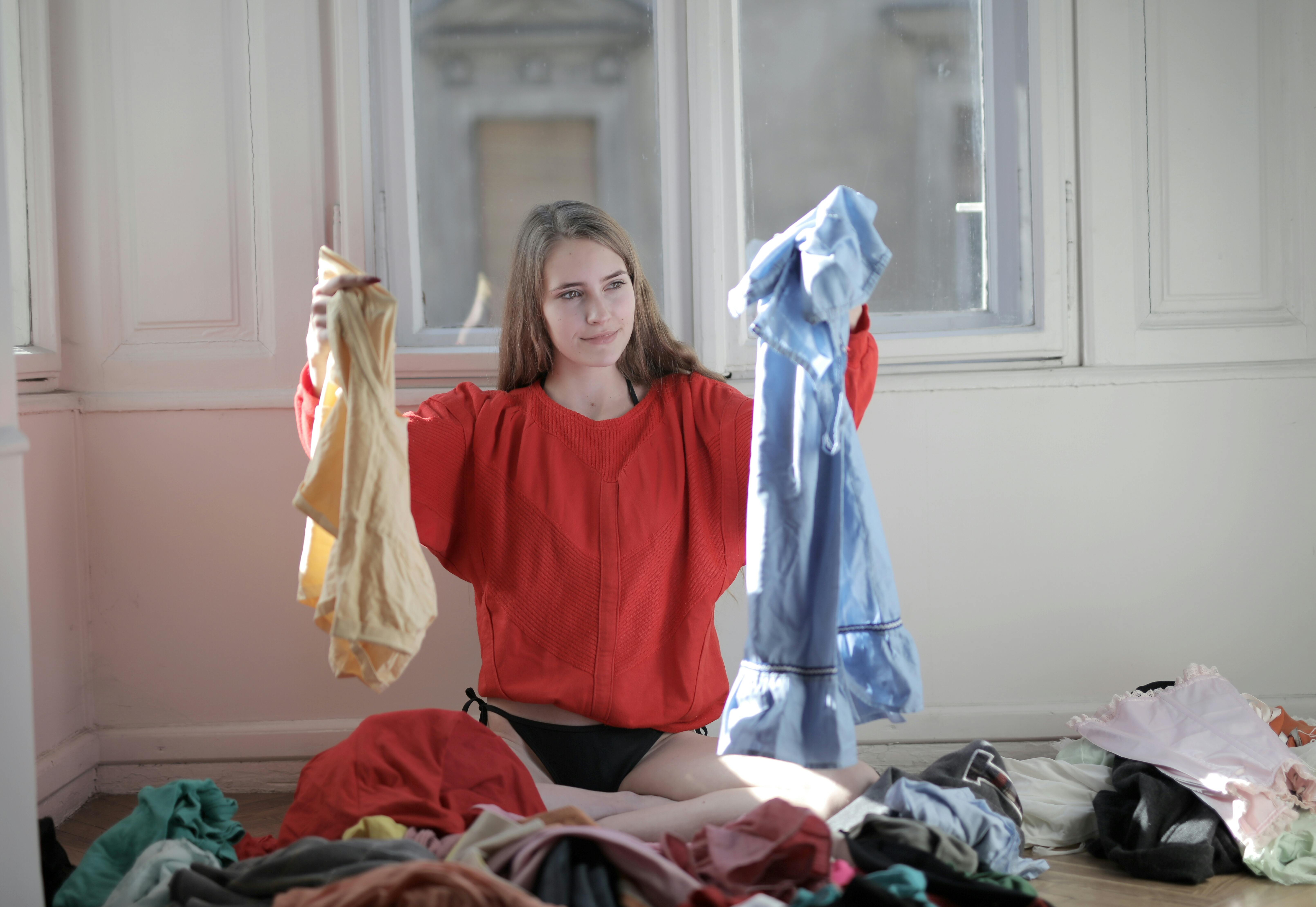 Mujer sosteniendo piezas de ropa de la lavandería | Fuente: Pexels