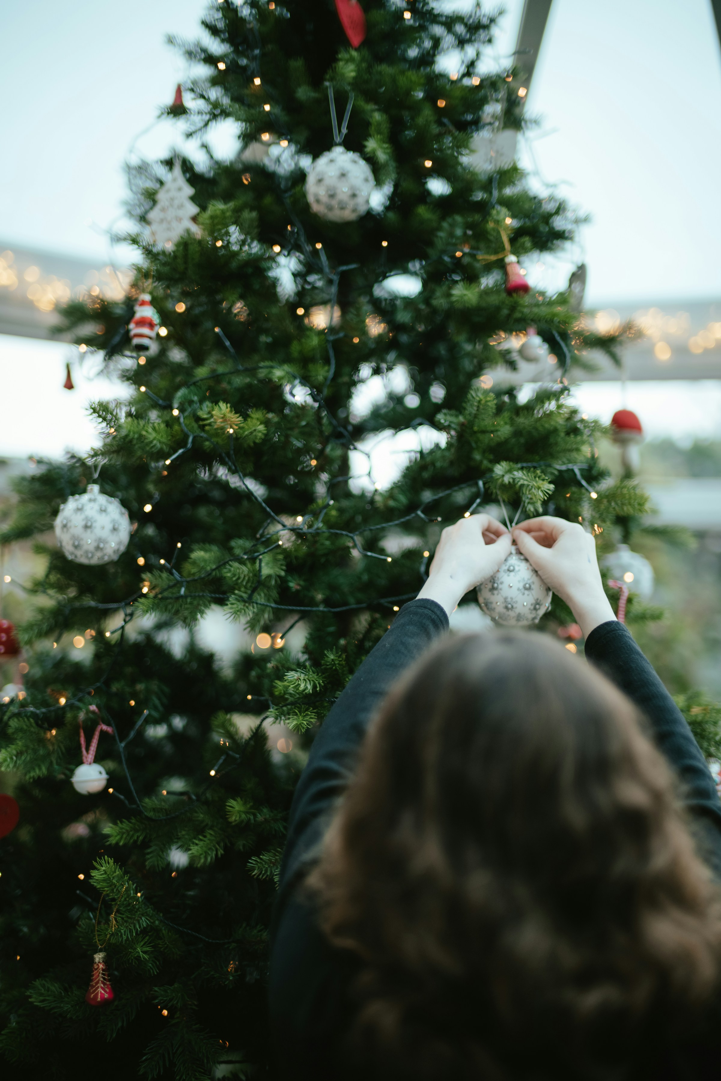 Una mujer decorando un árbol de Navidad | Fuente: Unsplash