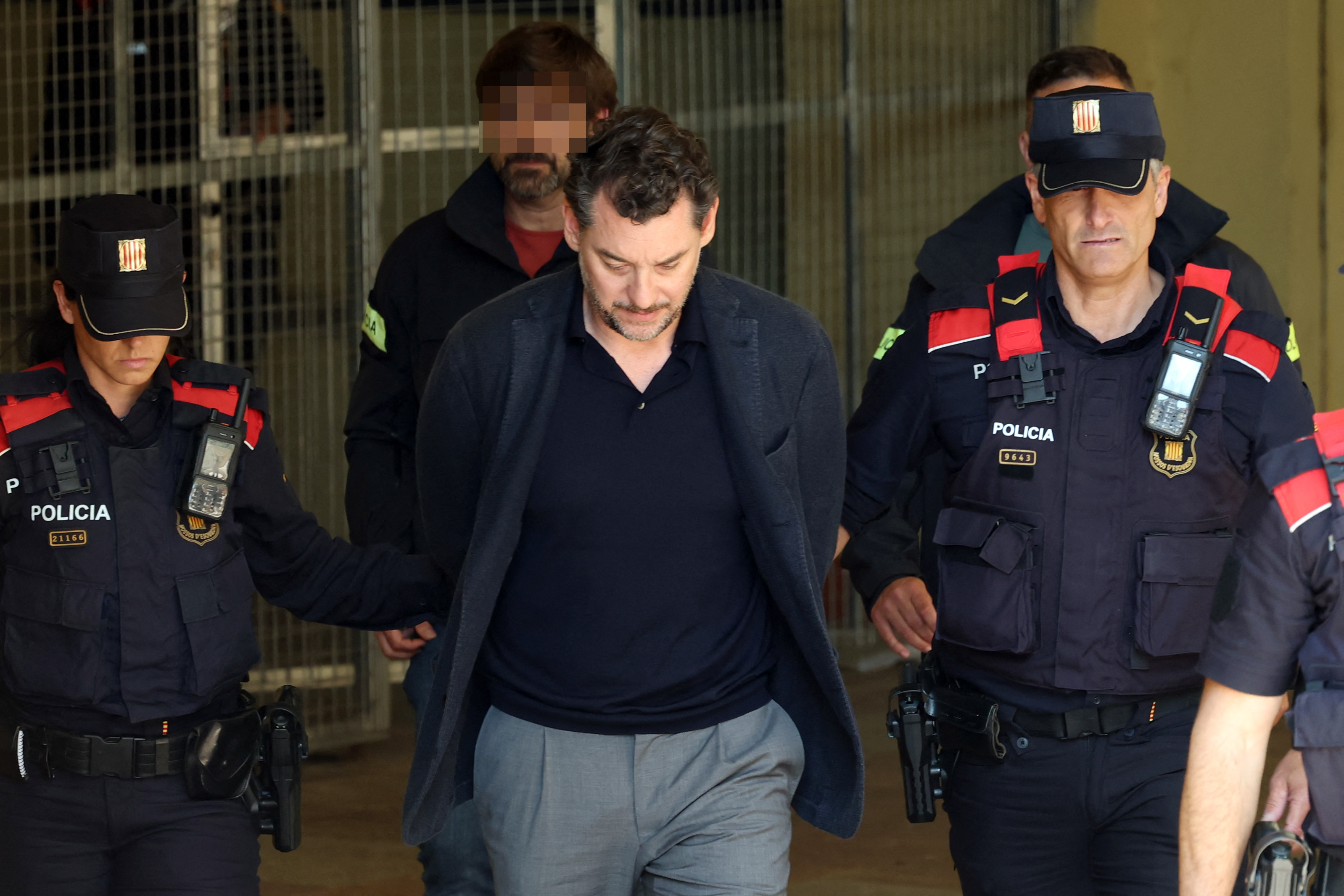 Agentes de la policía regional catalana (Mossos d'Esquadra) escoltan a Jonathan Andic, hijo de Isak Andic, fundador de la marca de moda española Mango, a su llegada a un juzgado en Martorell, cerca de Barcelona, ​​tras su detención el 19 de mayo de 2026. | Fuente: Getty Images