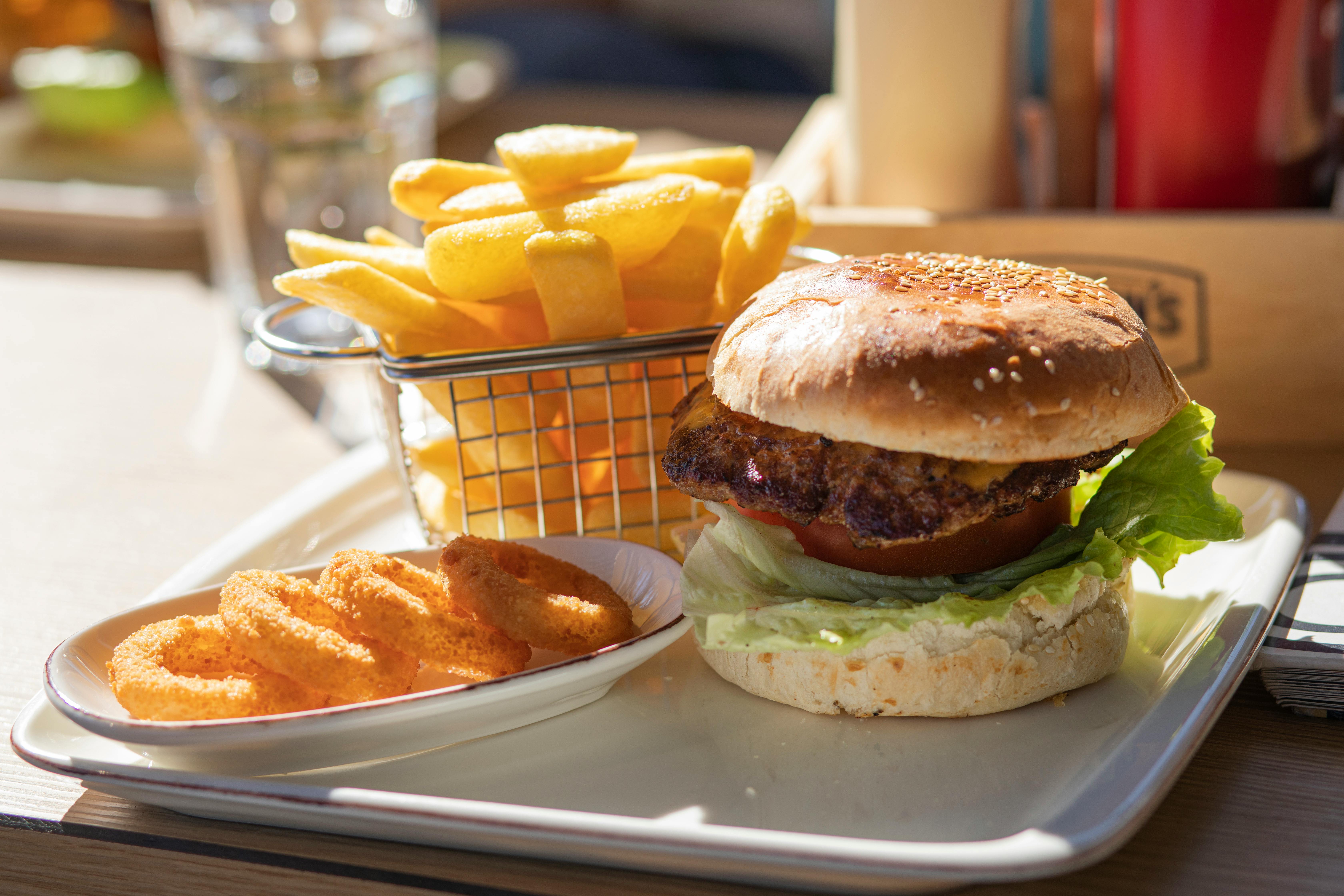 Una bandeja de hamburguesas, patatas fritas y aros de cebolla | Fuente: Pexels