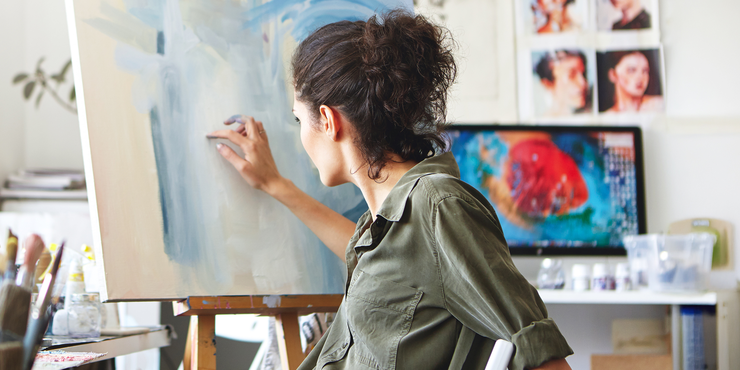 Una mujer pintando un cuadro sobre un lienzo | Fuente: Shutterstock