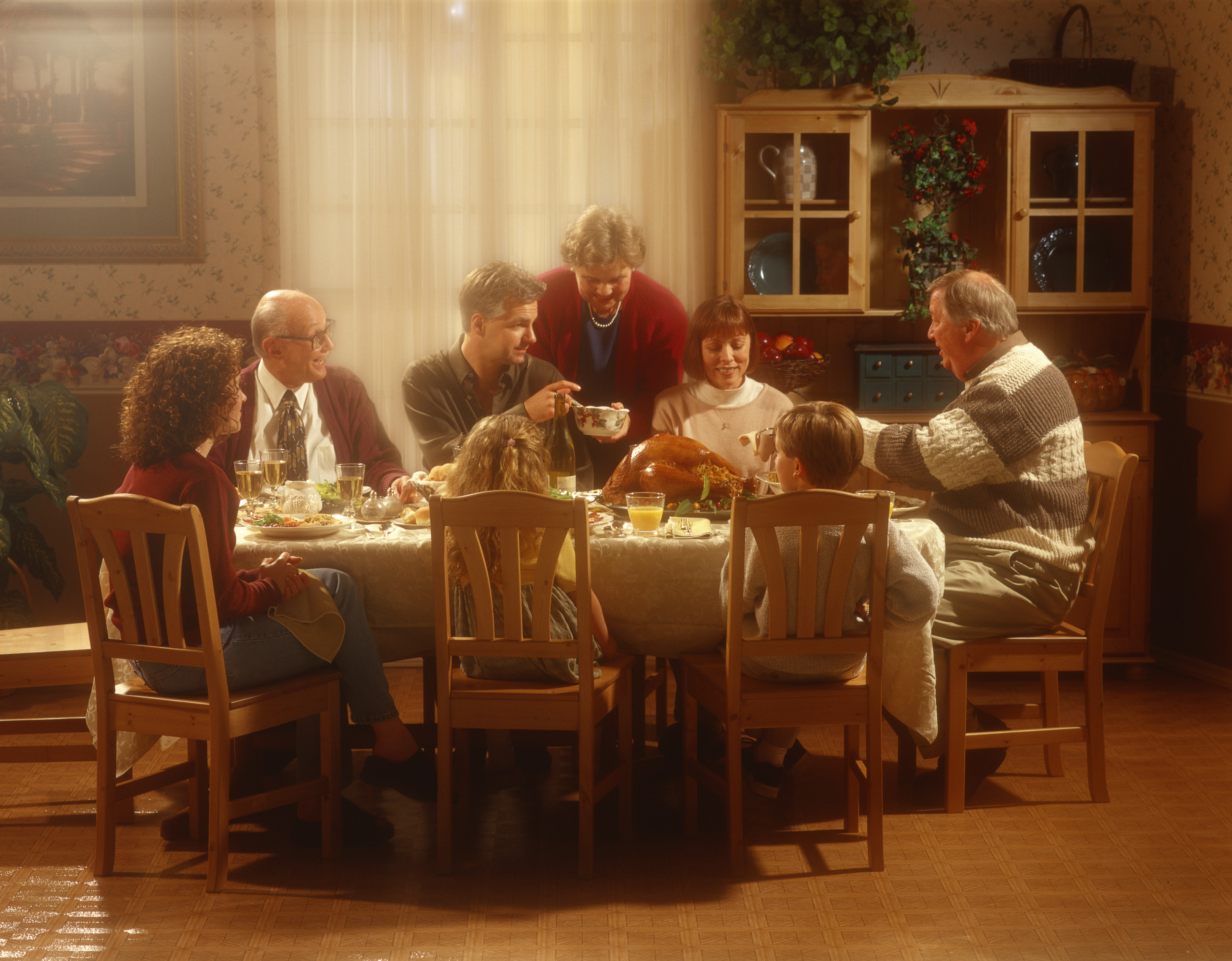 Familia sentada a la mesa | Foto: Getty Images