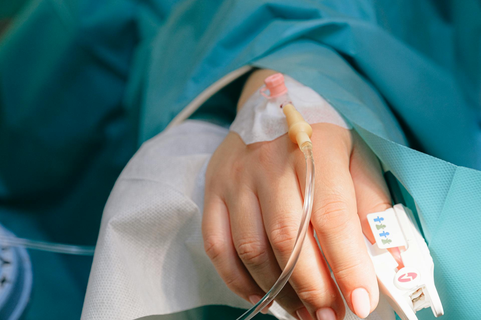 Primer plano de la mano de una mujer con una vía intravenosa | Fuente: Pexels