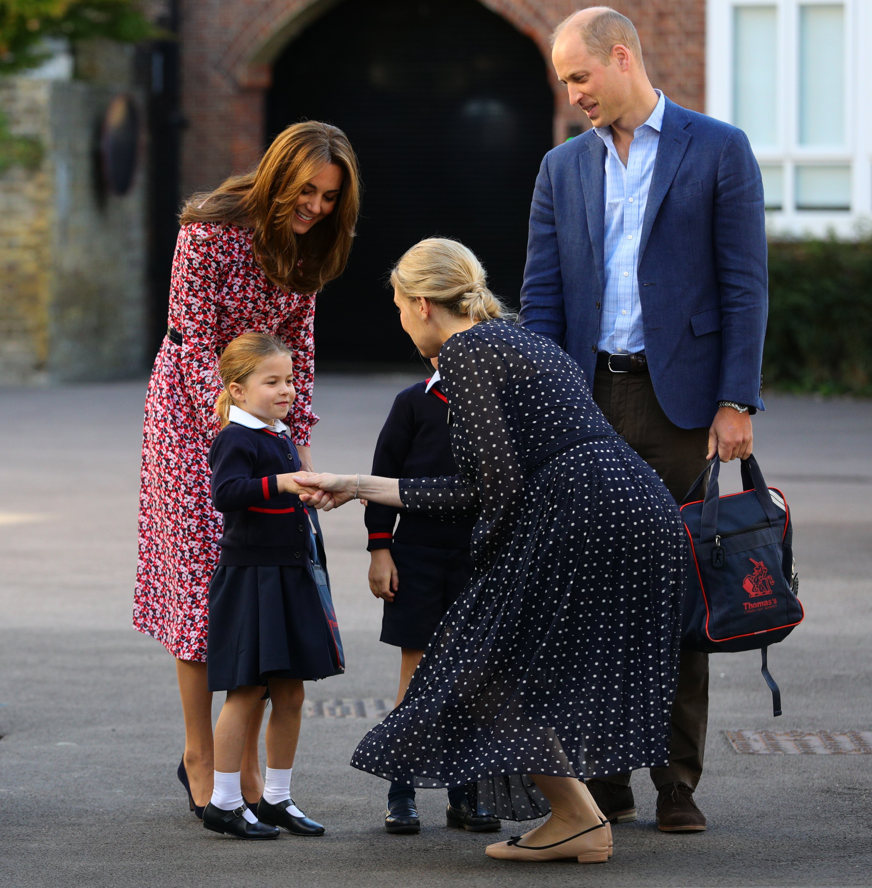 Helen Haslem saluda a la princesa Charlotte en su primer día de colegio, junto a sus padres Kate Middleton y el príncipe William, en Thomas's Battersea en Londres el 5 de septiembre de 2019, en Londres, Inglaterra | Foto: Getty Images