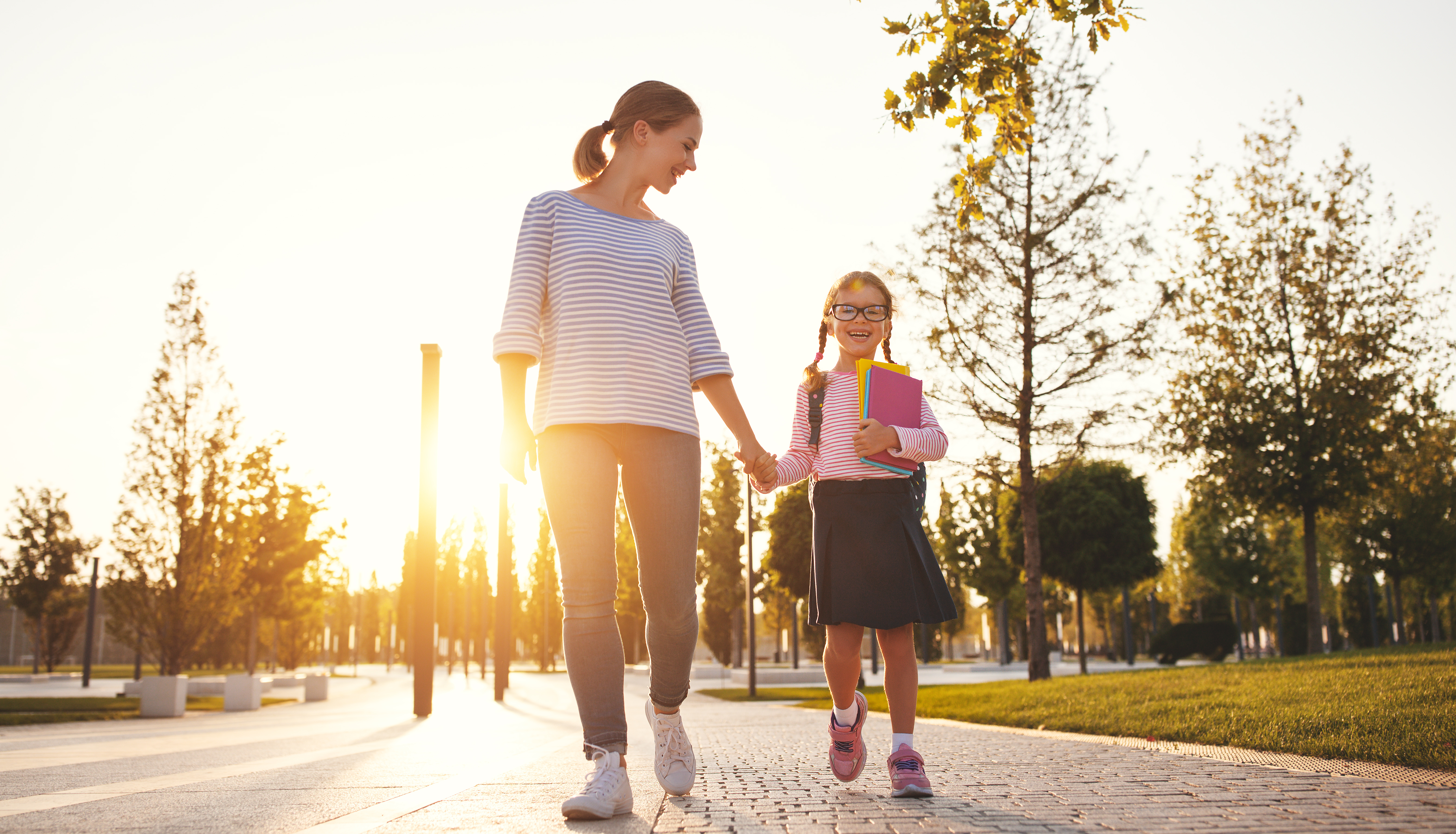 Una madre conduce a una niña al colegio en primer curso | Foto: Getty Images