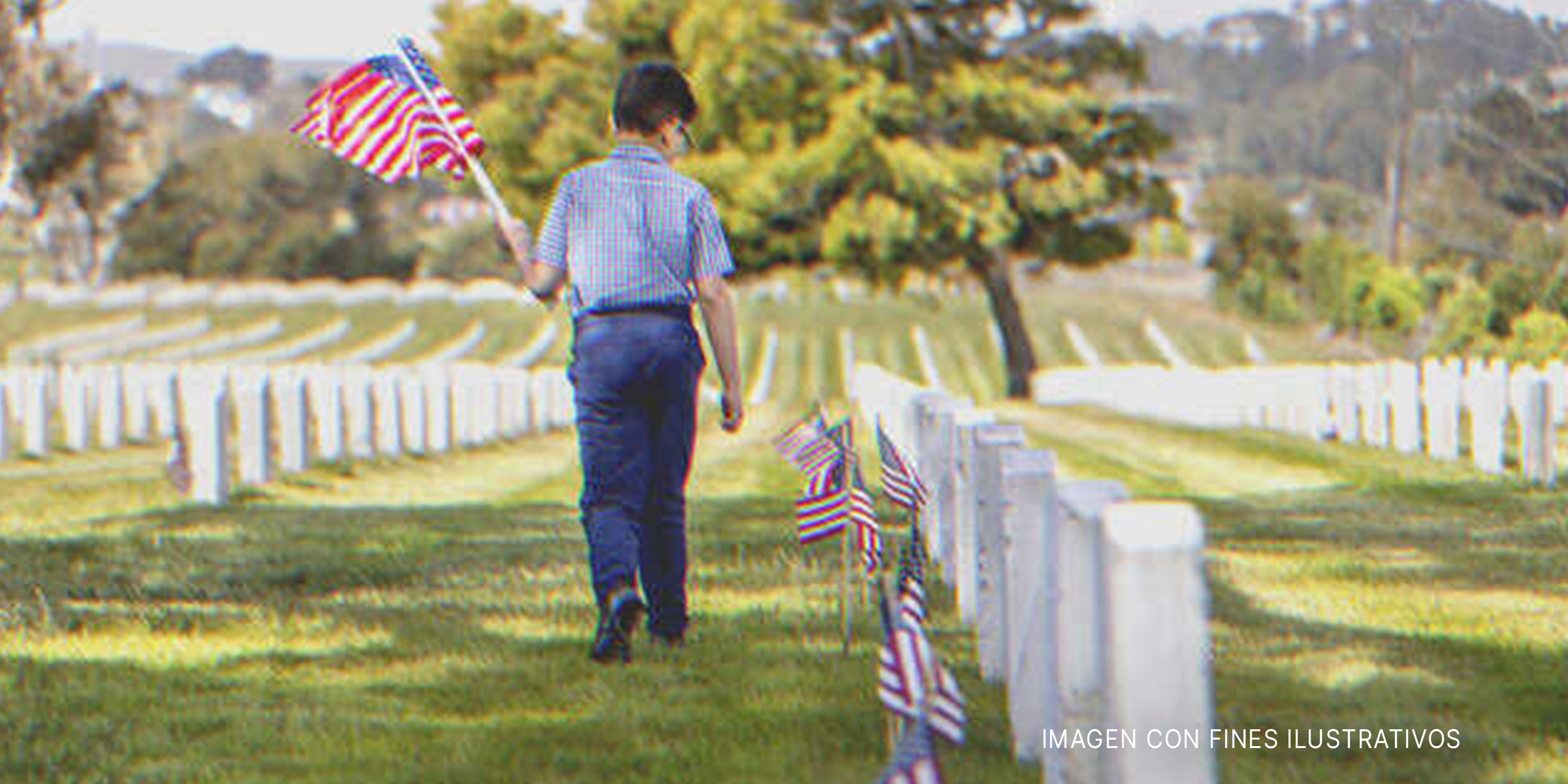 Niño con la bandera nacional de EE.UU. en un cementerio. | Foto: Getty Images