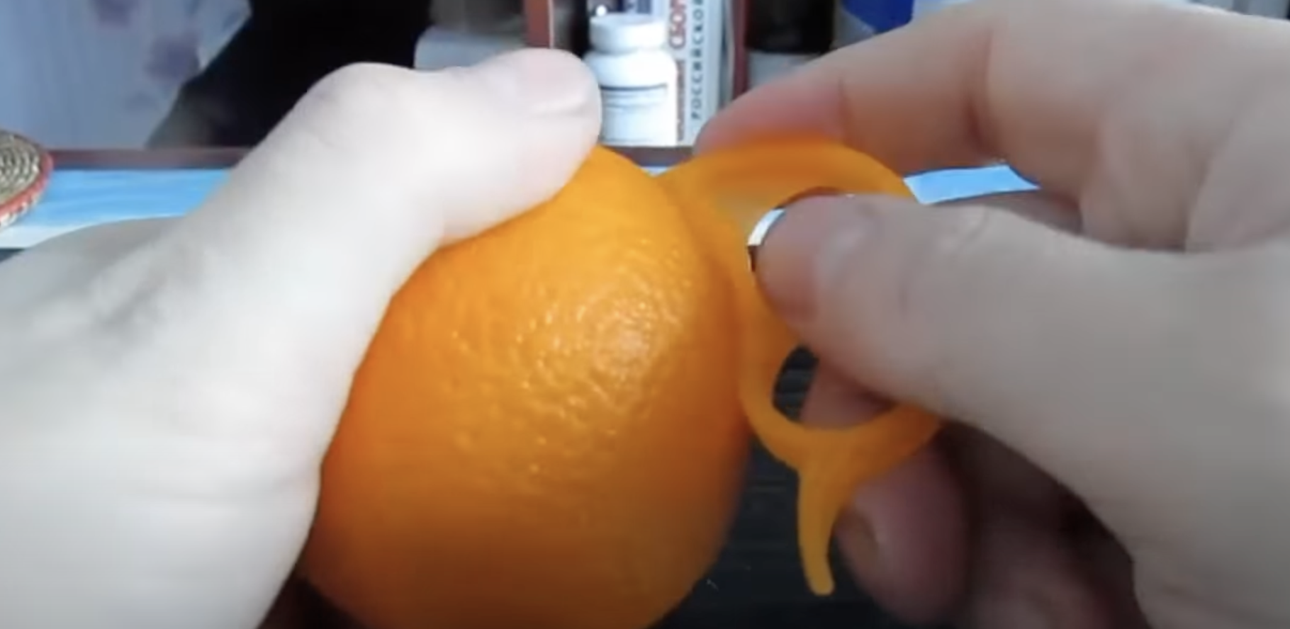 Una persona utilizando un pelador de naranjas | Foto: youtube.com/zetira4582