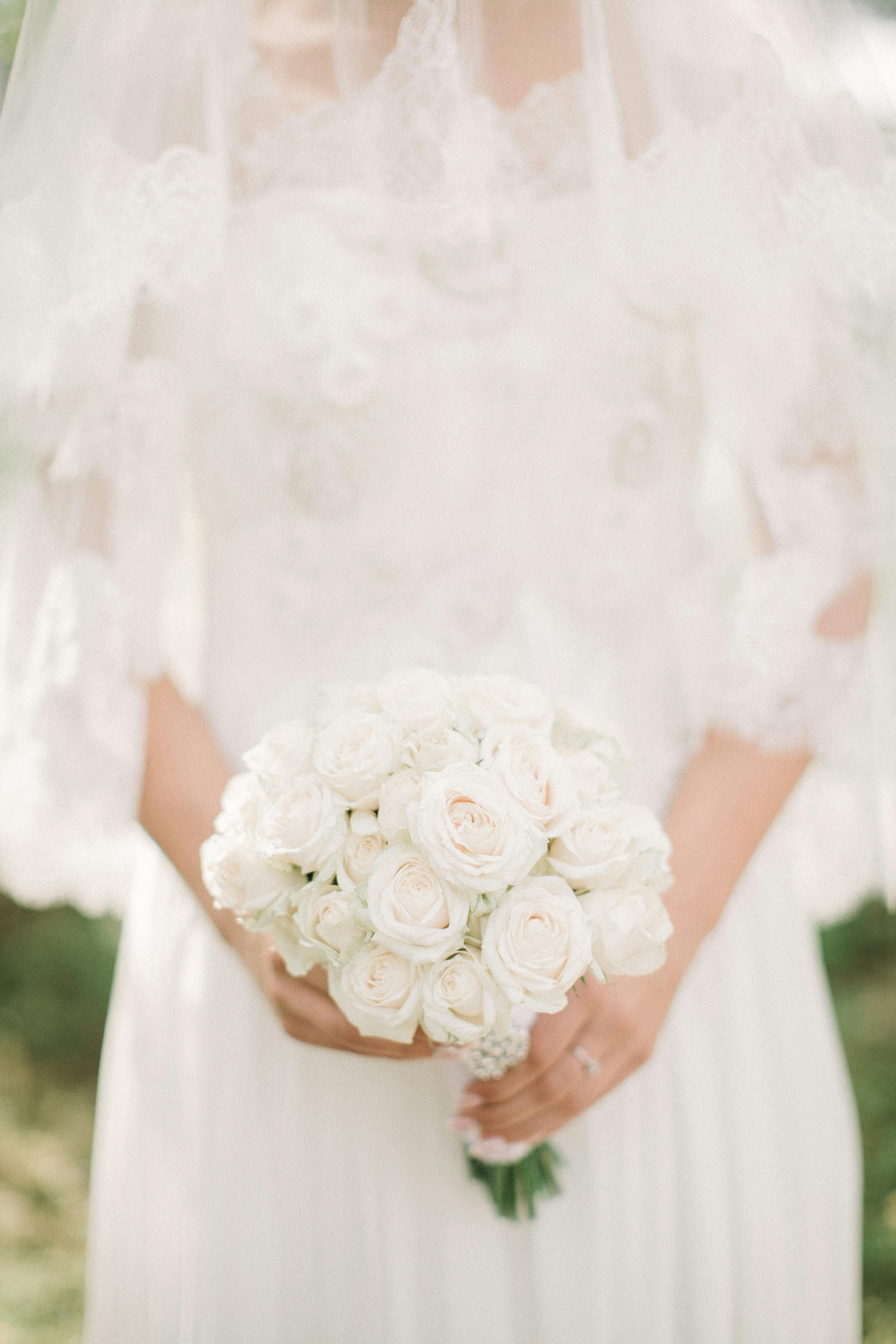Una novia sosteniendo flores blancas | Fuente: Pexels