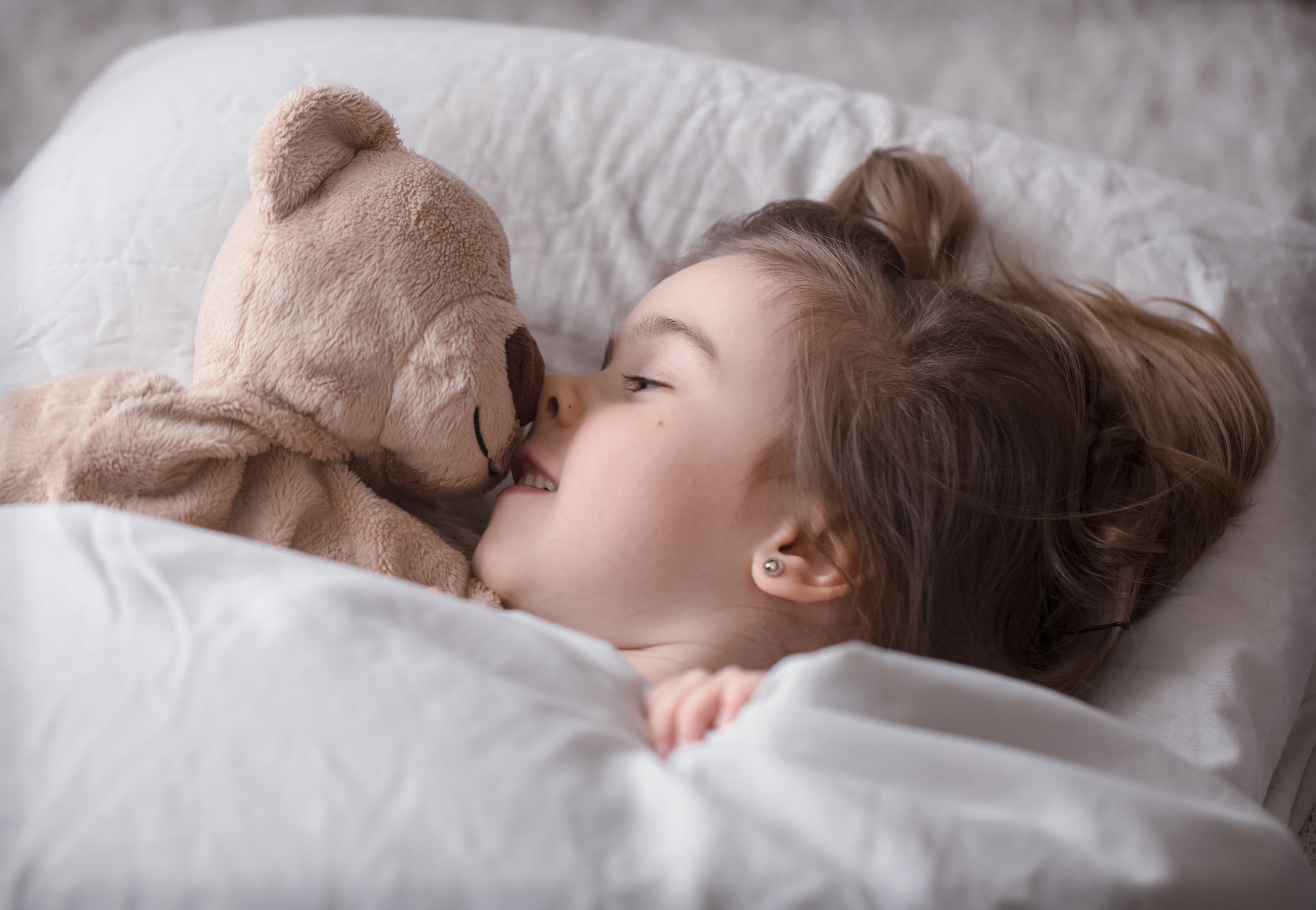 Una chica sonriente en su cama | Fuente: Freepik