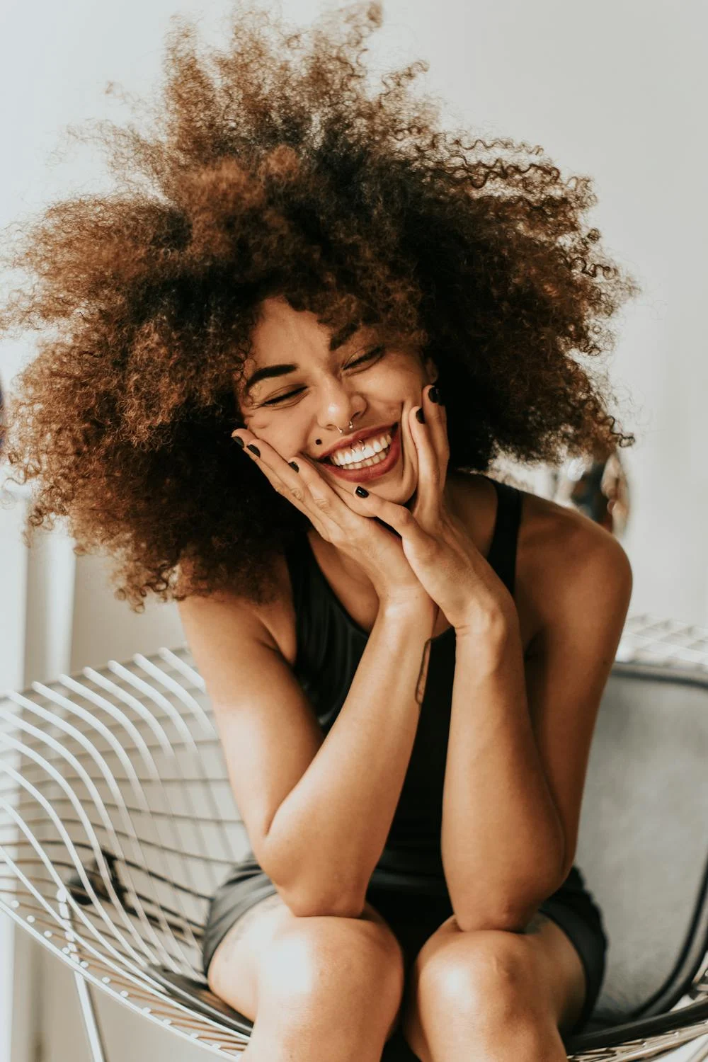 Una mujer sonriente en una silla | Fuente: Pexels