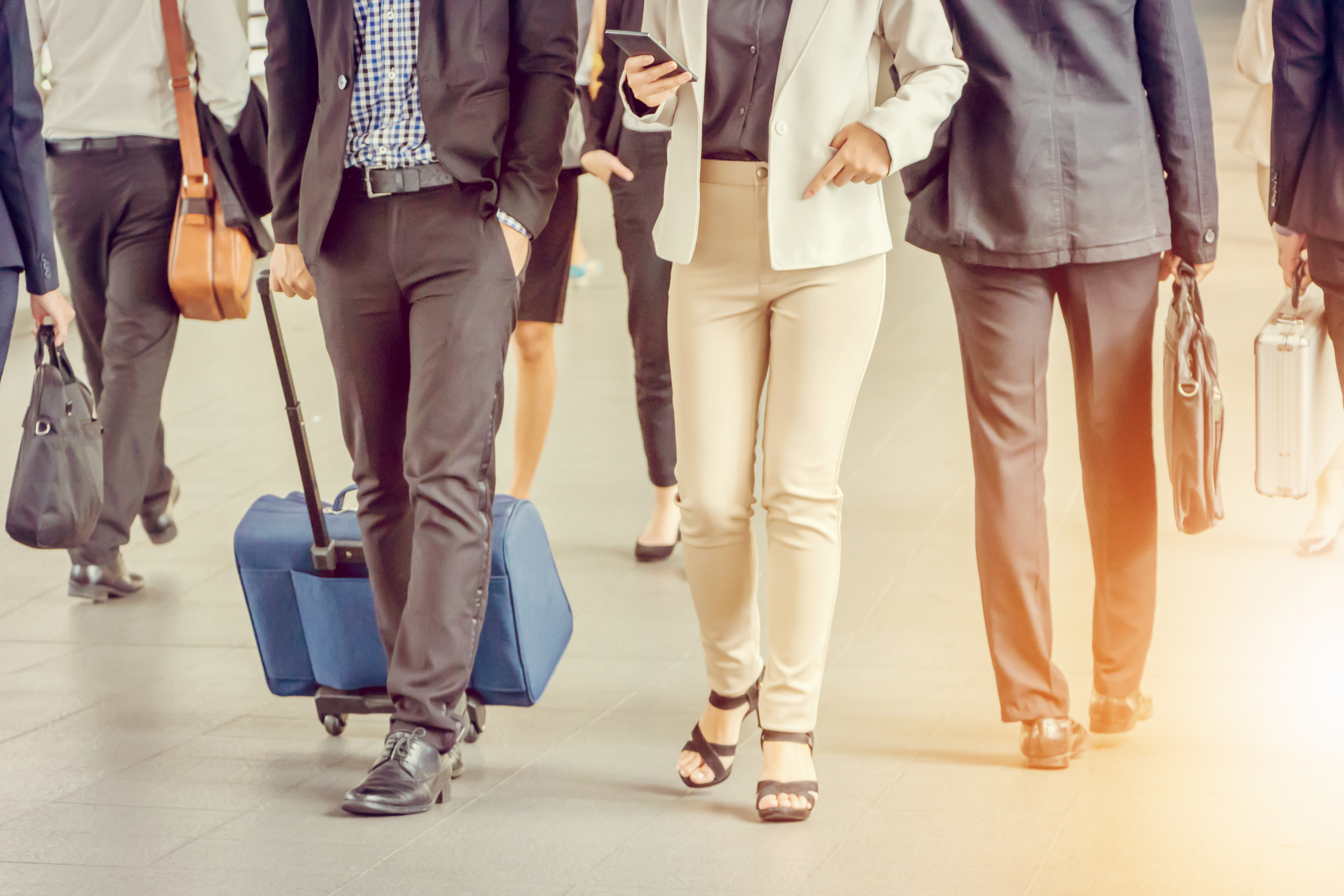 Hombre de negocios y mujer de negocios viajeros con equipaje | Fuente: Shutterstock