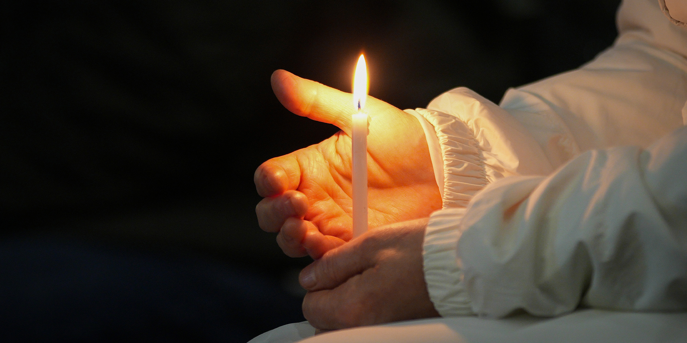 Vela encendida en manos de una monja. | Foto: Getty Images