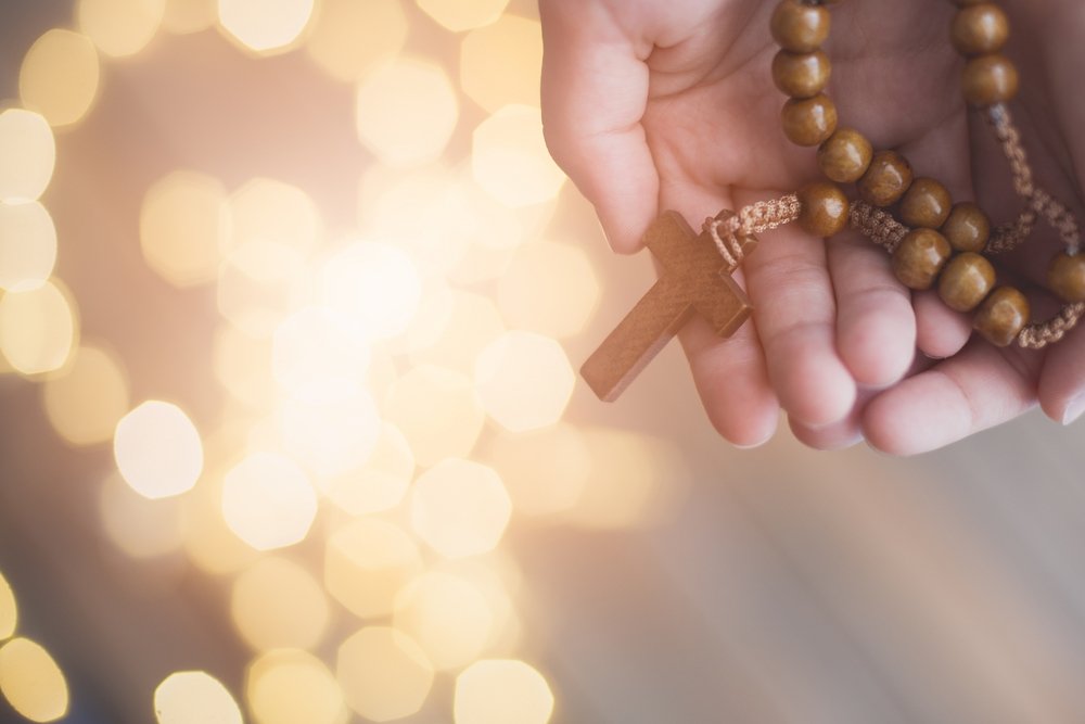 Persona con un rosario en sus manos.| Fuente: Shutterstock