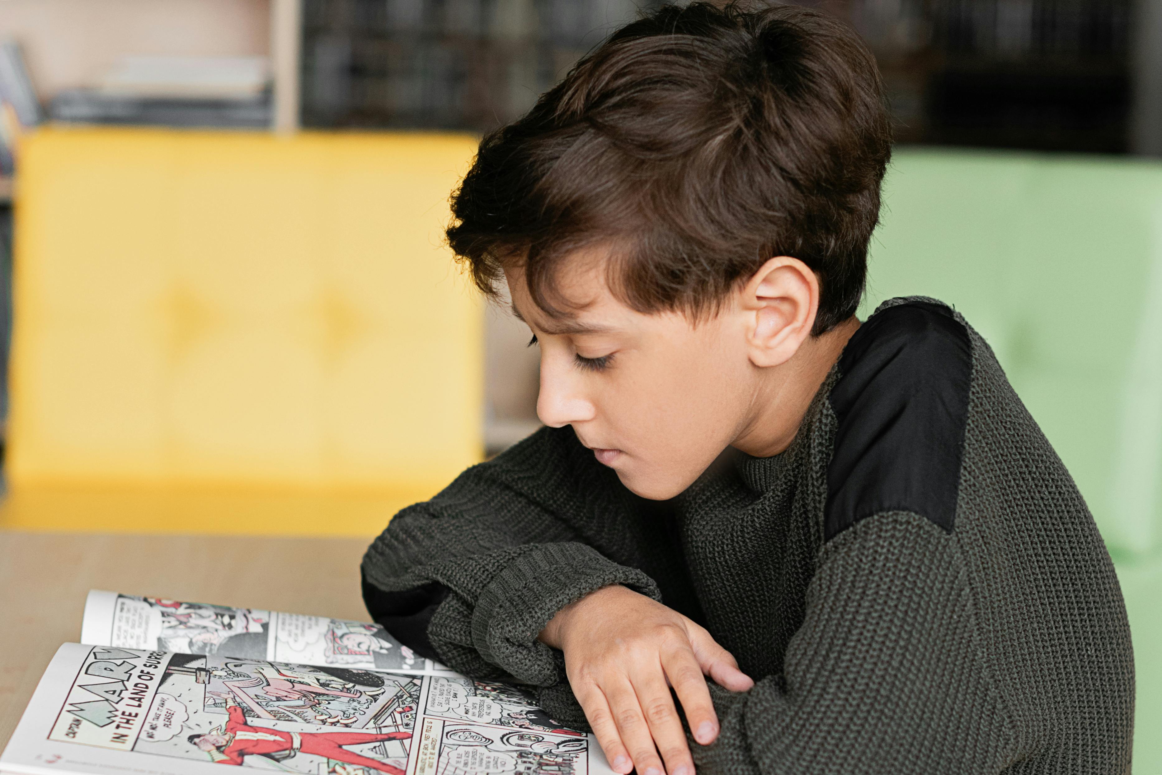 Un ragazzino che legge un fumetto | Fonte: Pexels