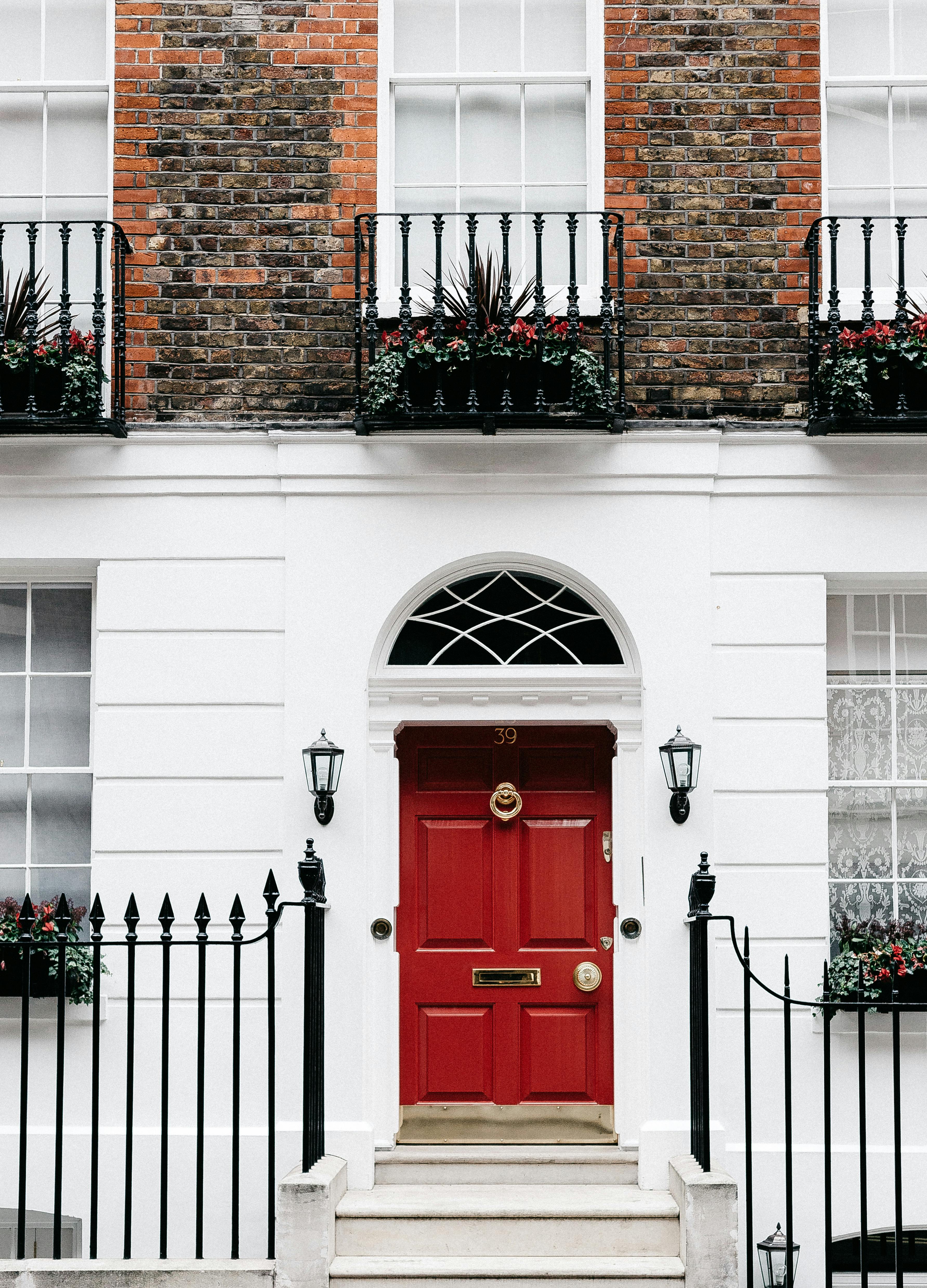 Fachada de un edificio de viviendas con una puerta roja | Fuente: Pexels