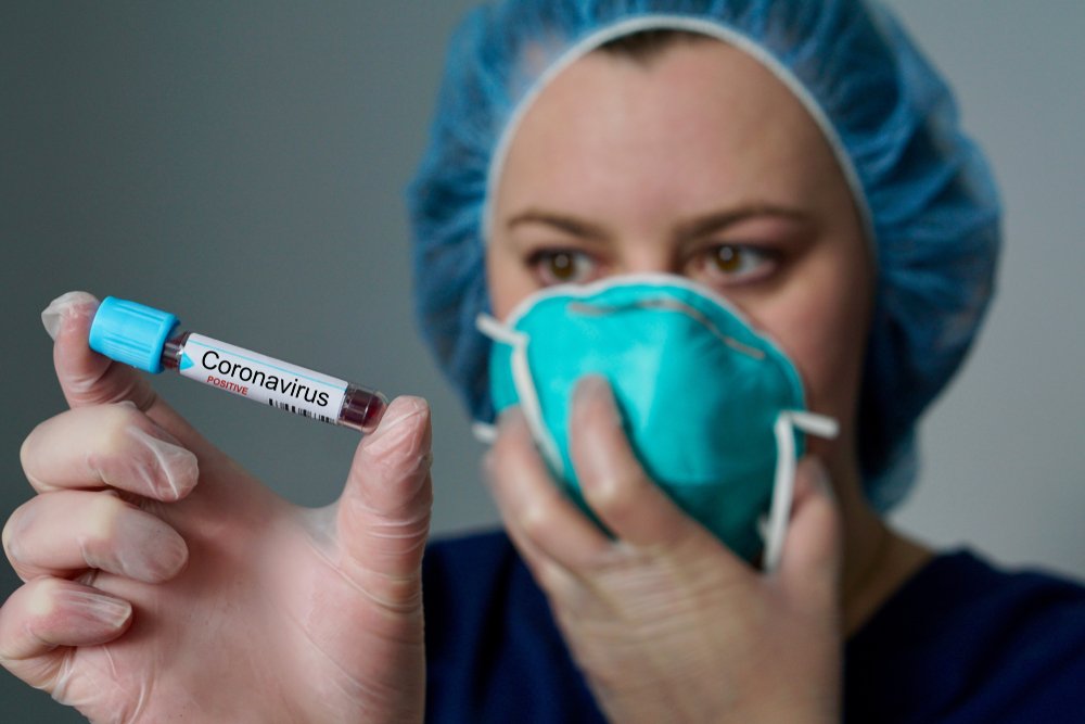 Enfermera sosteniendo prueba positiva para coronavirus. I Foto: Shutterstock.