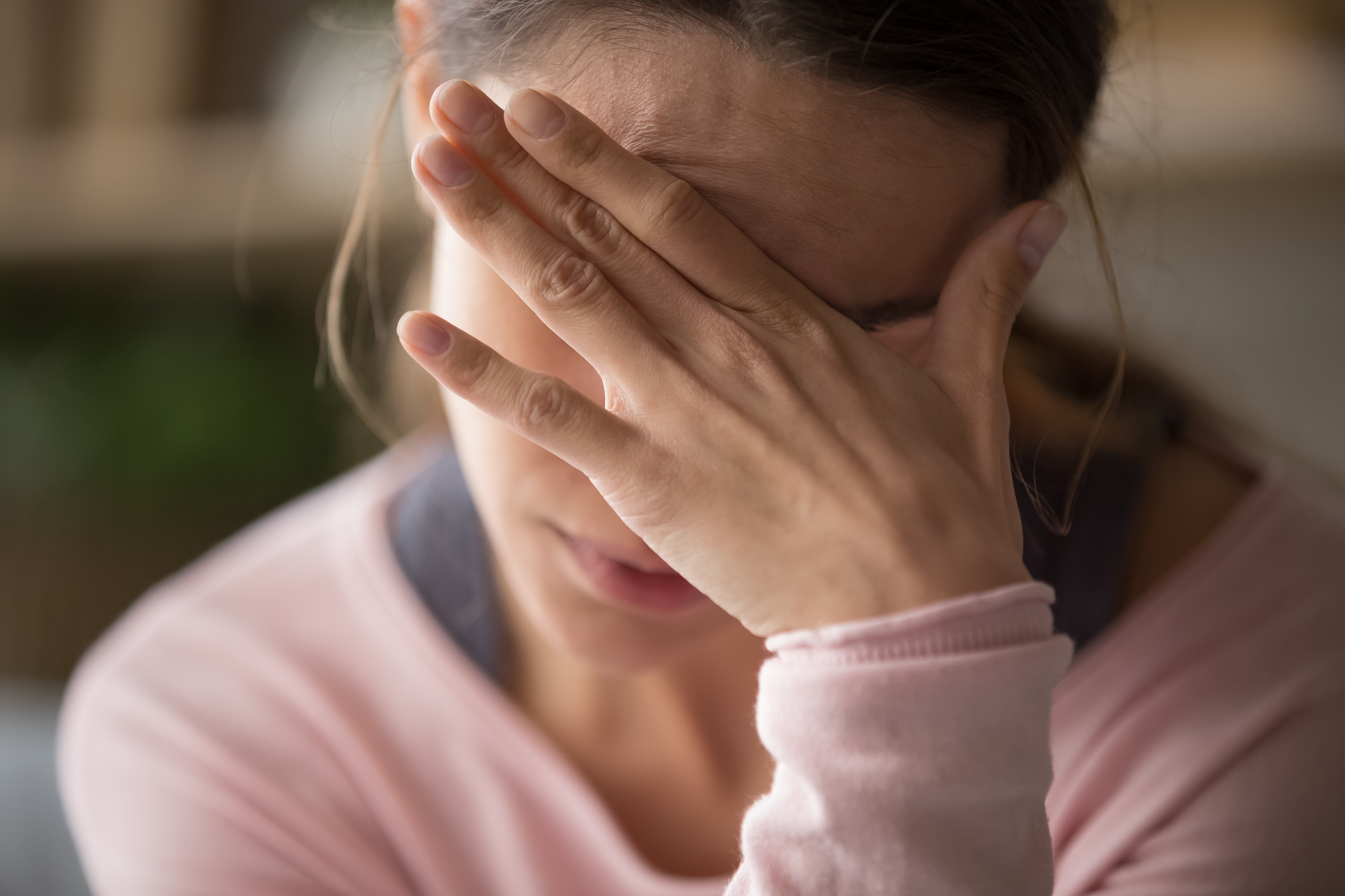 Una mujer sentada con la mano en la cara | Foto: Shutterstock