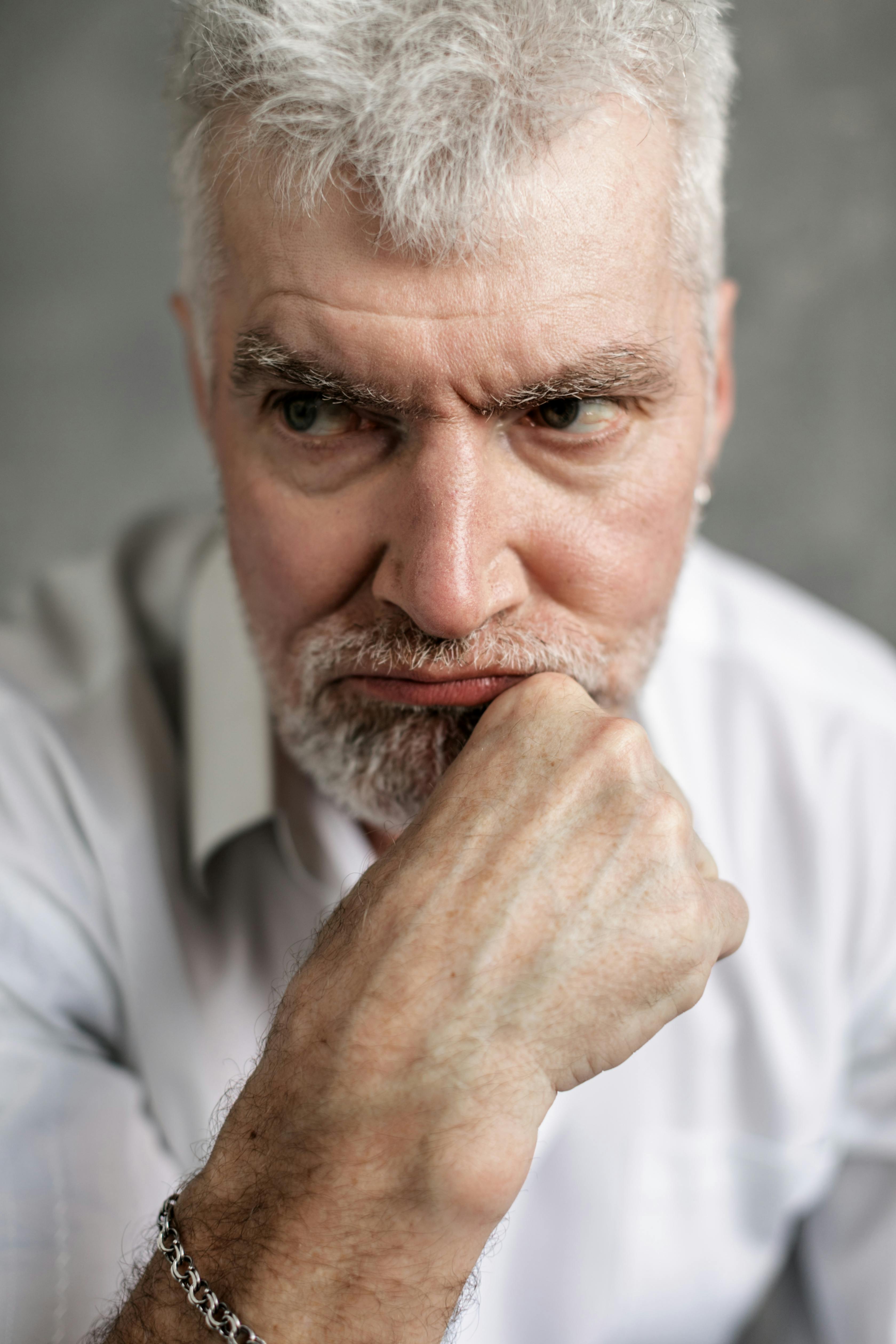 Un hombre malhumorado con la barbilla apoyada en la mano | Fuente: Pexels