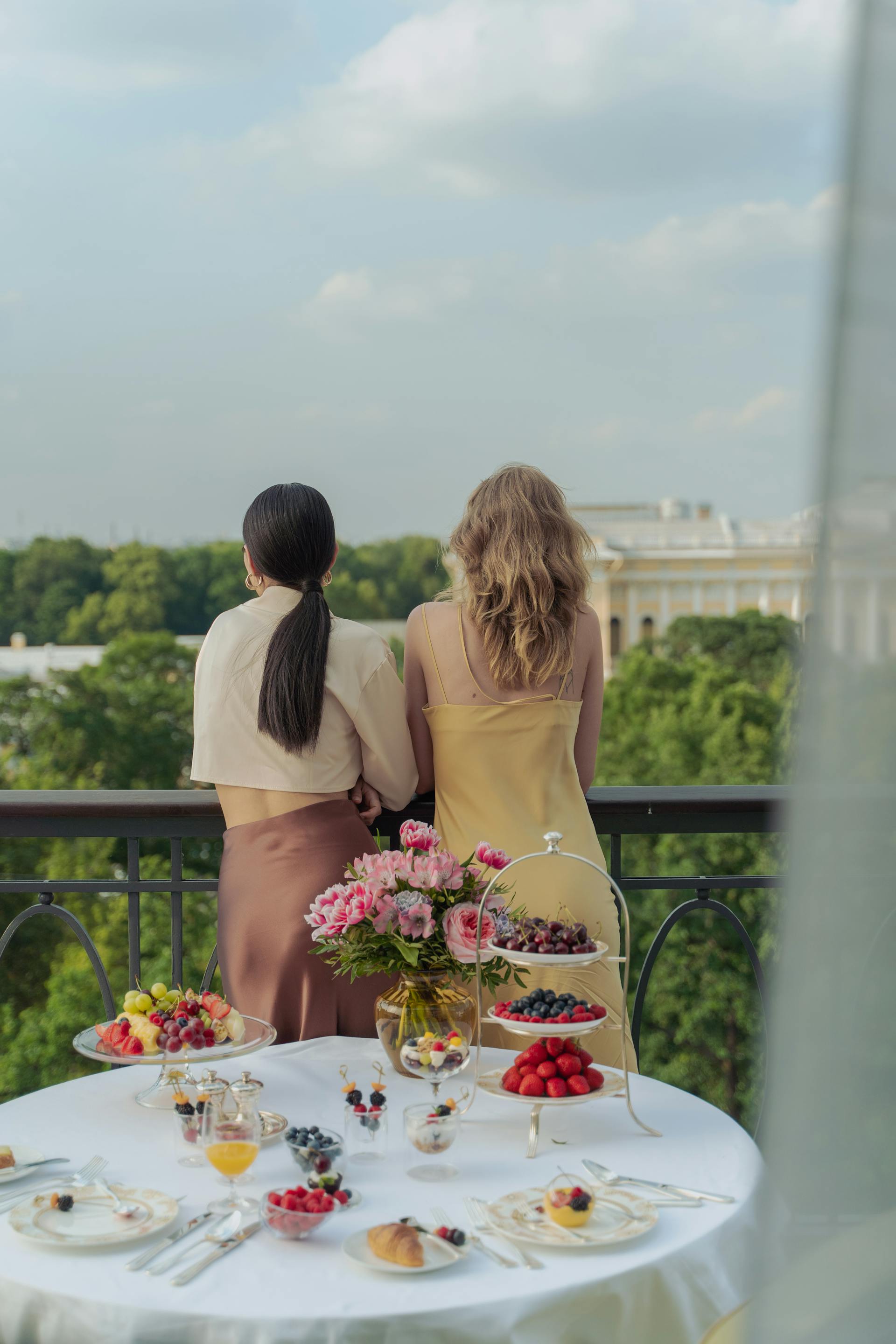 Una vista trasera de mujeres de pie en un balcón | Foto: Pexels