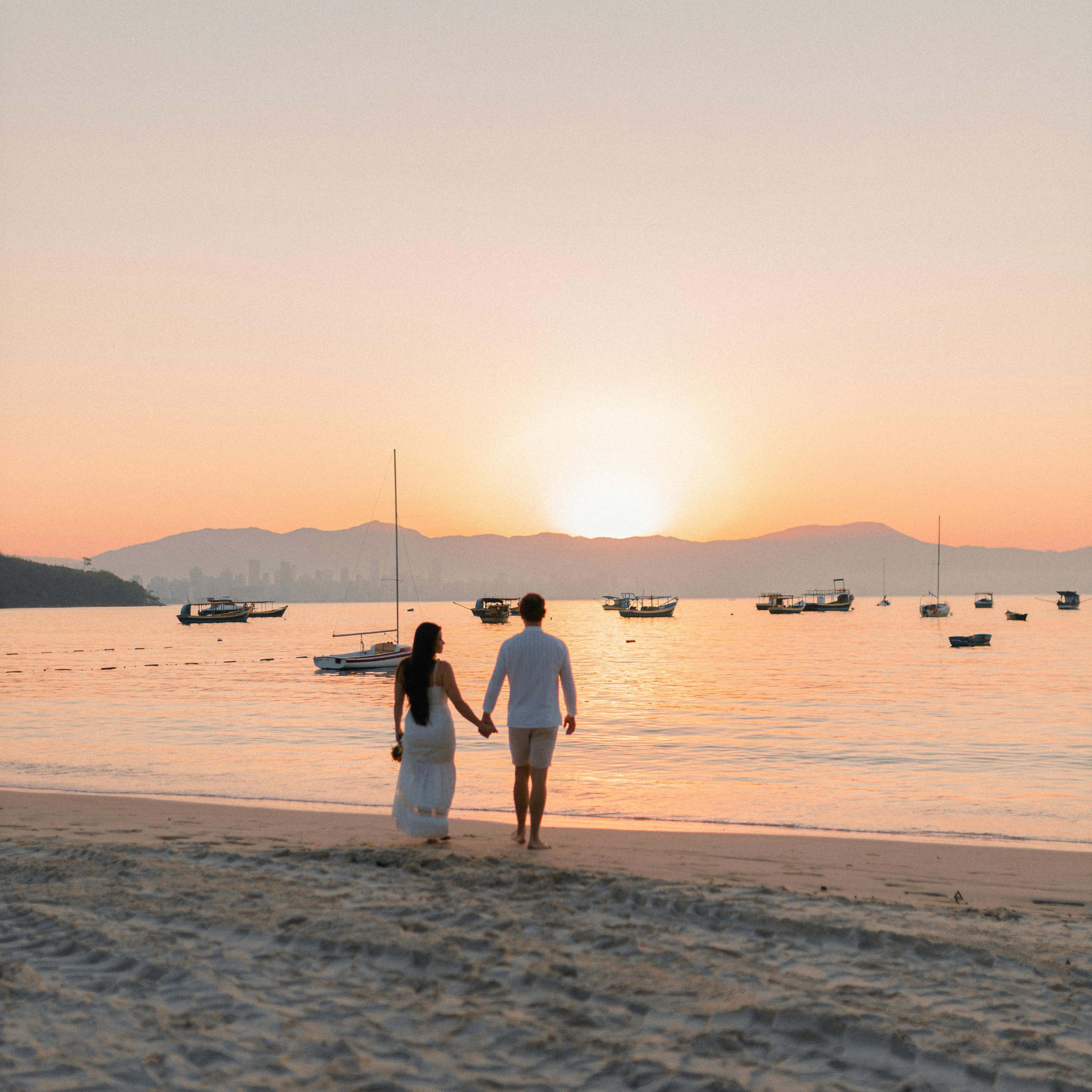 Una pareja paseando por una playa, tomados de la mano | Fuente: Pexels