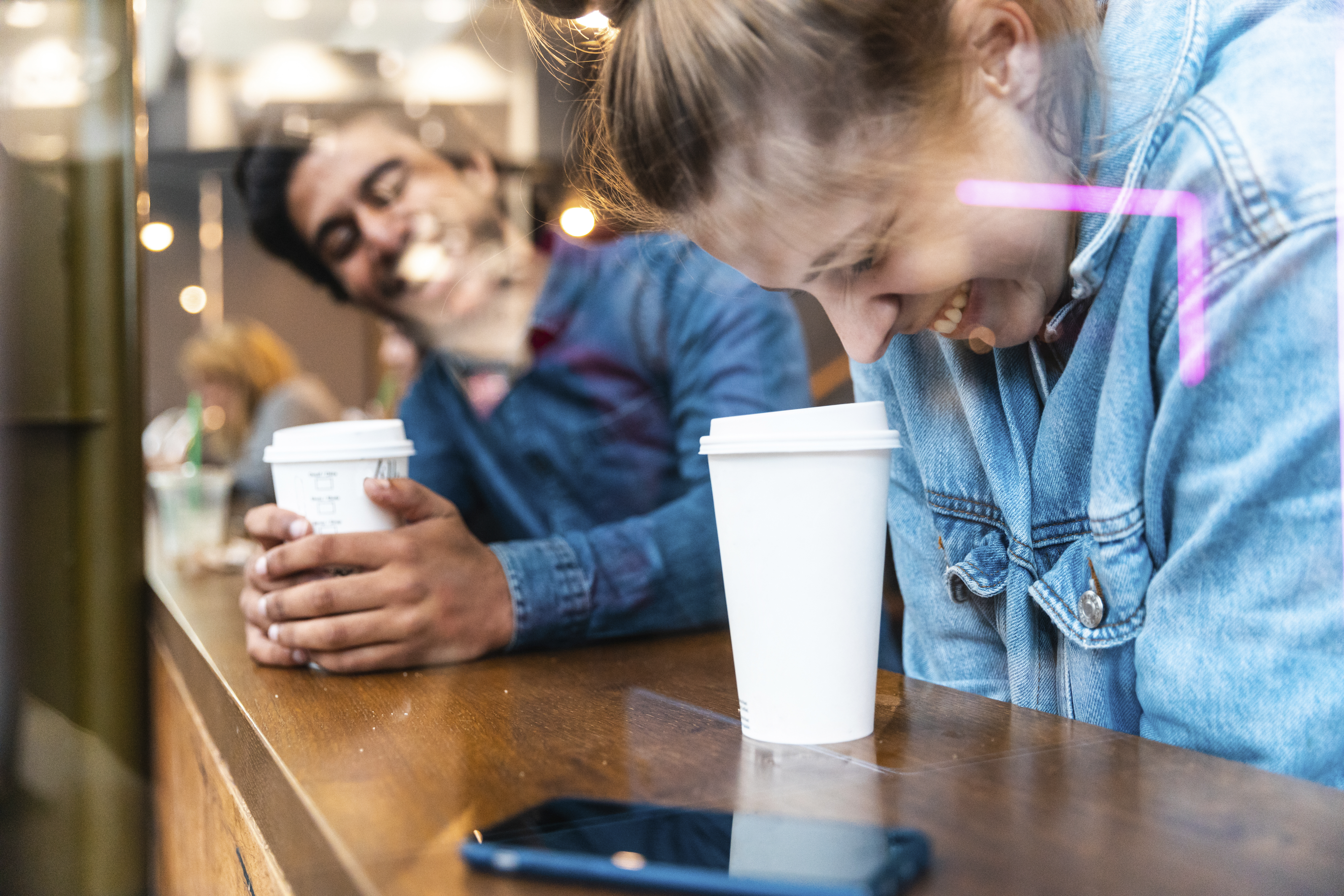 Amigos divirtiéndose juntos en una cafetería | Foto: Getty Images