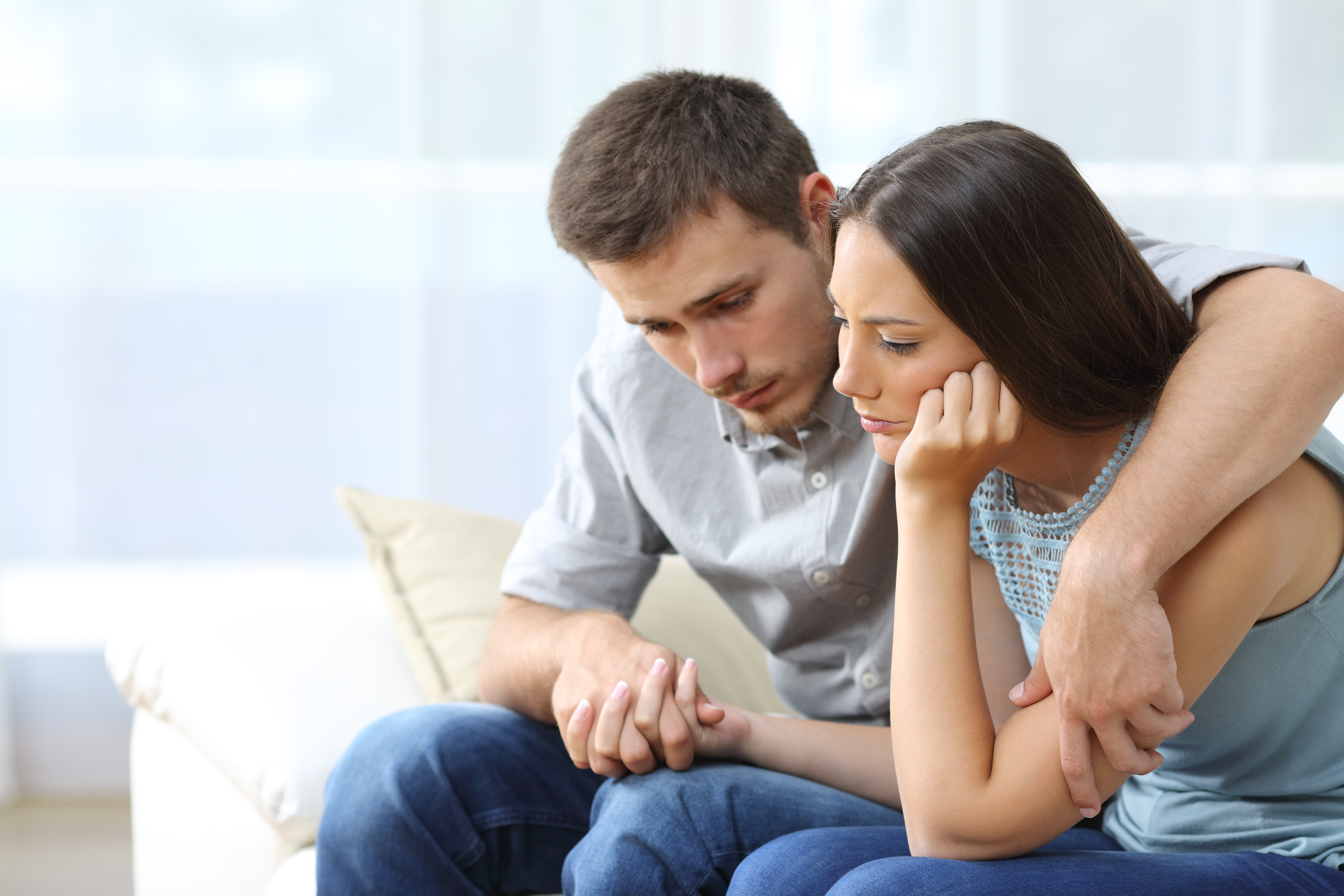 Una pareja triste consolándose mutuamente | Fuente: Shutterstock