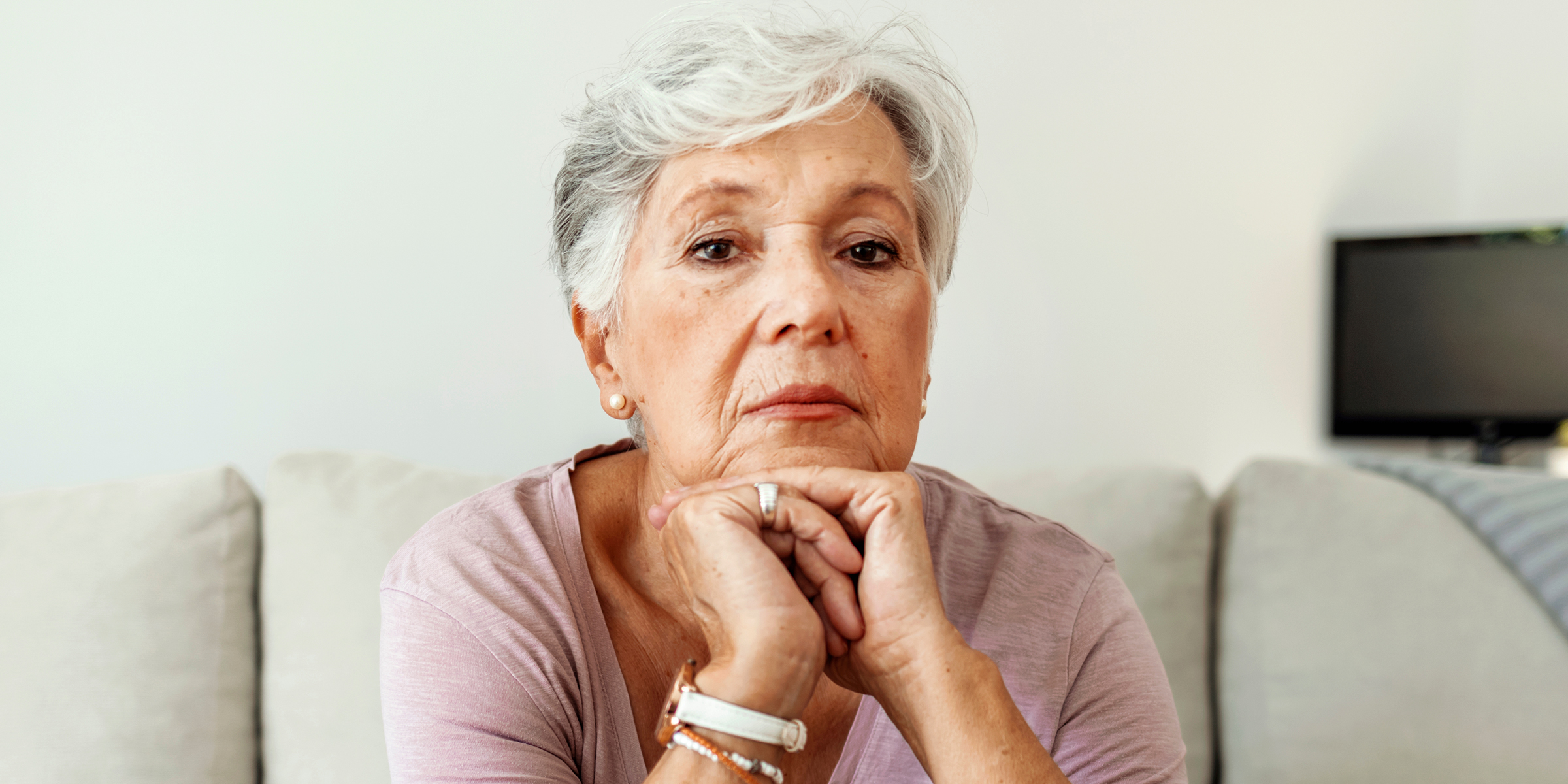 Una mujer mayor con las manos bajo la barbilla | Fuente: Shutterstock
