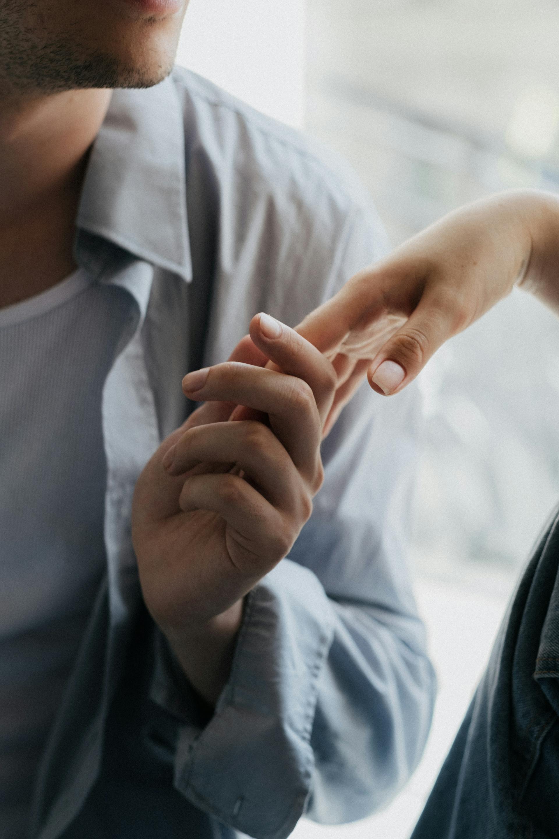 Un hombre tomando suavemente la mano de una mujer | Fuente: Pexels