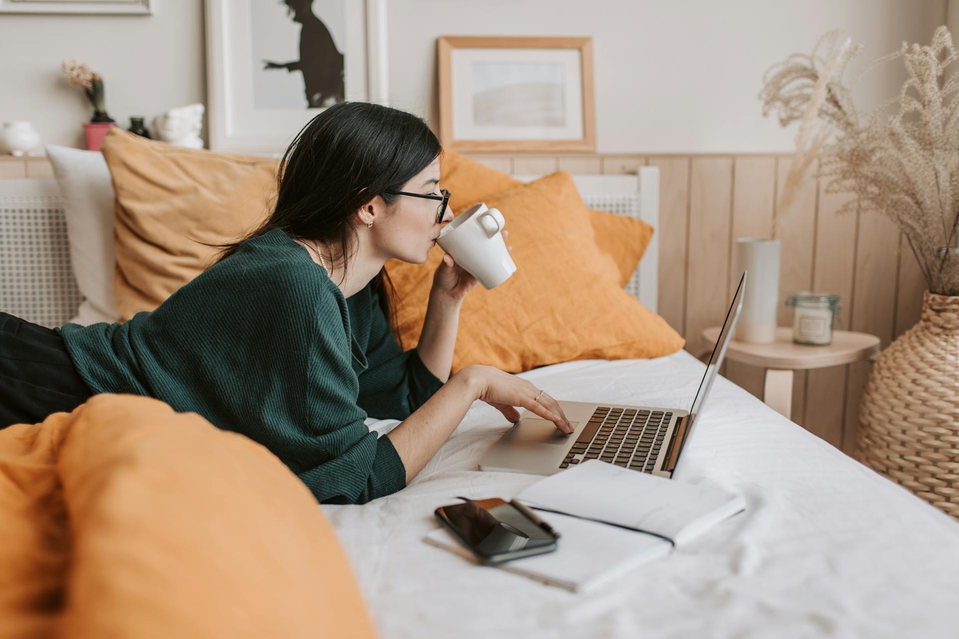 Una mujer usando el portátil en la cama | Fuente: Pexels